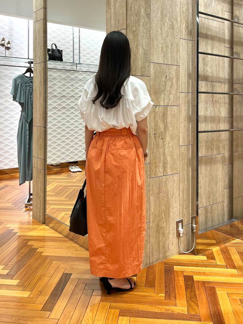 ホワイト系のシャツ/ブラウス、オレンジ系のスカートを着用したレディースの夏コーディネートの3枚目の写真