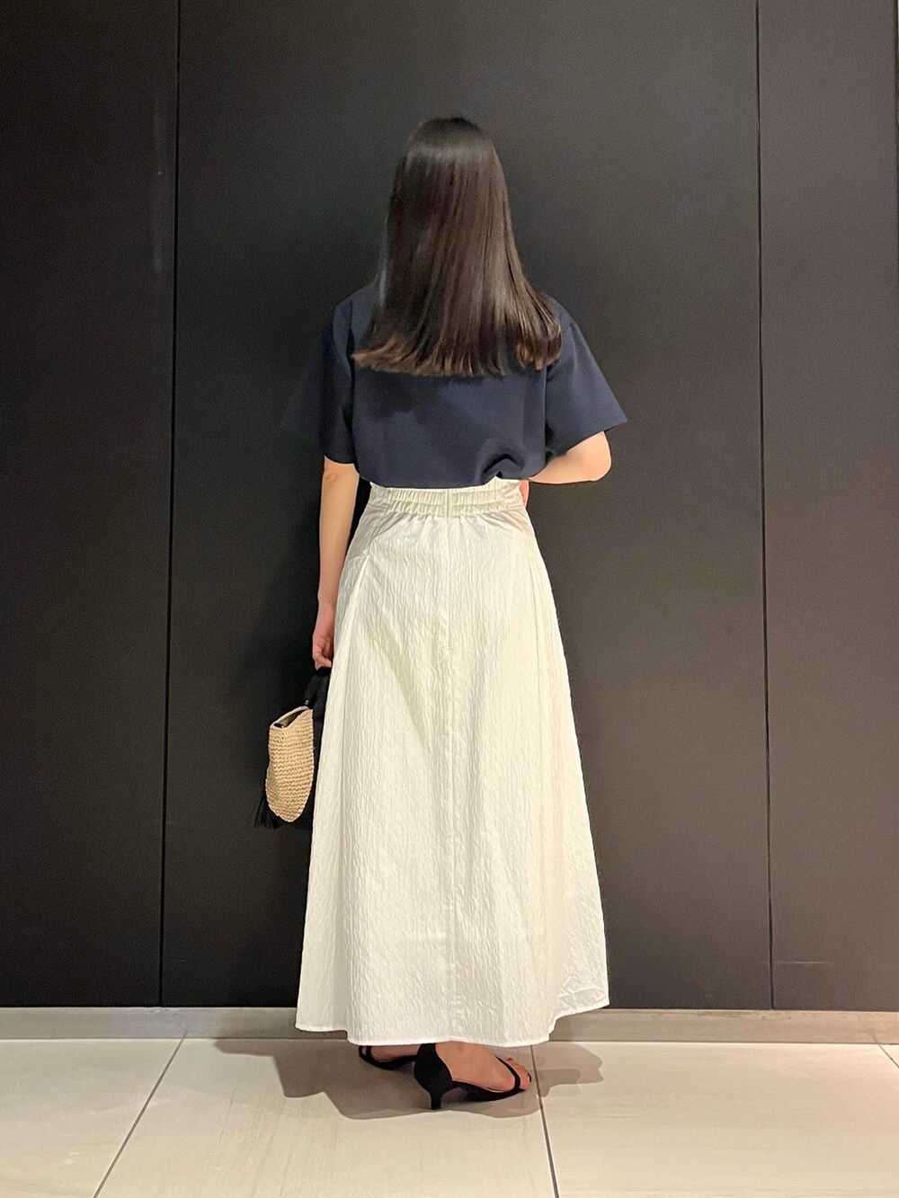 ブルー系のTシャツ/カットソー、ホワイト系のスカート、ベージュ系のハンドバッグを着用したレディースの春コーディネートの3枚目の写真