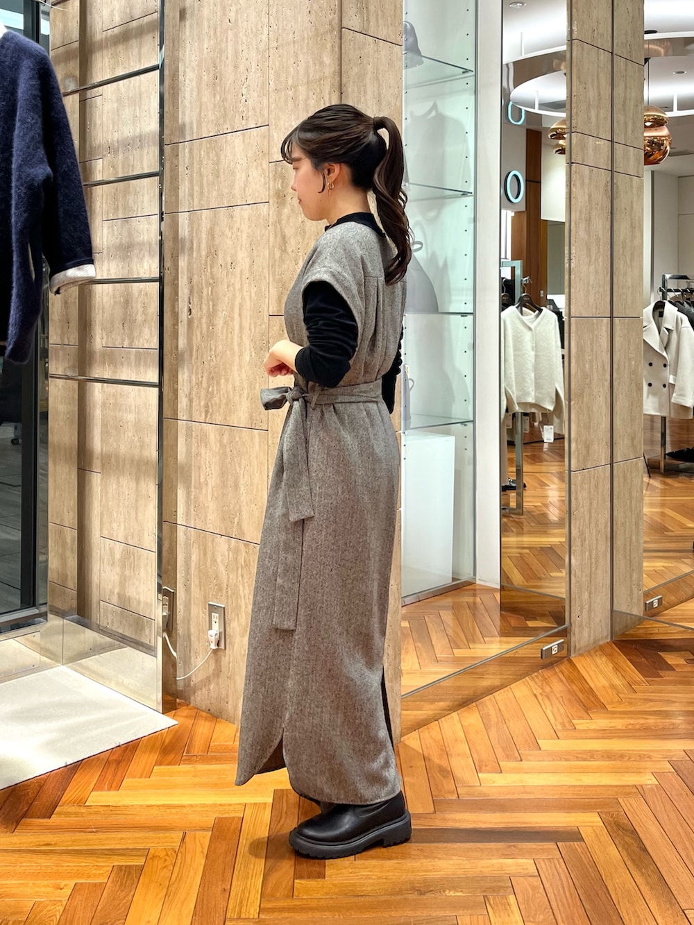 グレー系のワンピース、ブラック系のニット/セーターを着用したレディースの秋コーディネートの2枚目の写真