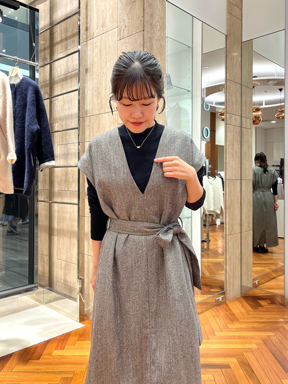 グレー系のワンピース、ブラック系のニット/セーターを着用したレディースの秋コーディネートの4枚目の写真