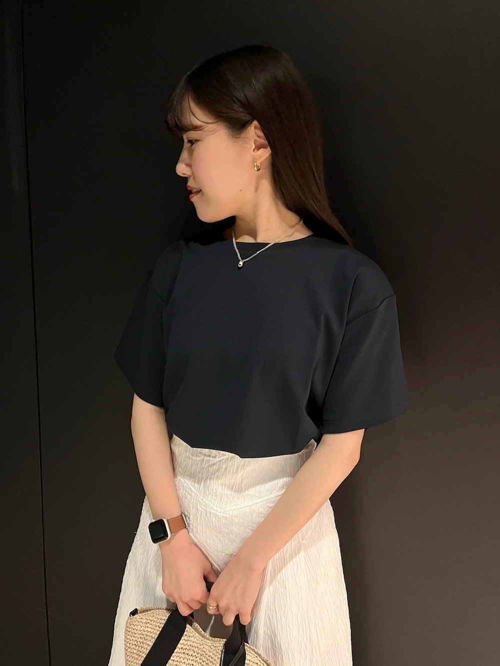 ブルー系のTシャツ/カットソー、ホワイト系のスカート、ベージュ系のハンドバッグを着用したレディースの春コーディネートの4枚目の写真