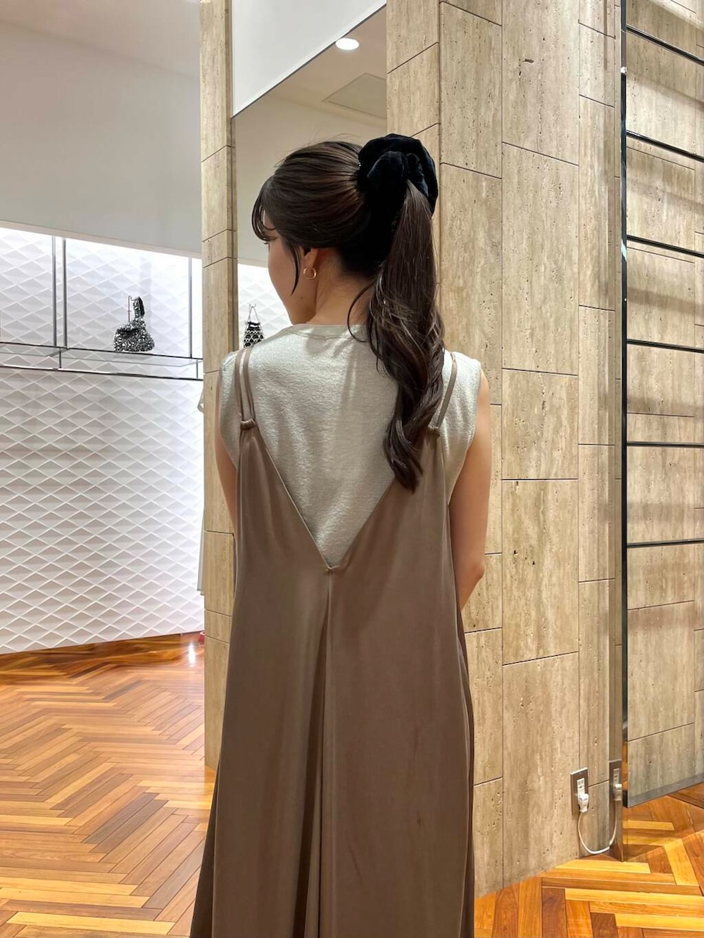 ベージュ系のニット/セーター、ベージュ系のワンピース、ブラック系のハンドバッグを着用したレディースの夏コーディネートの5枚目の写真