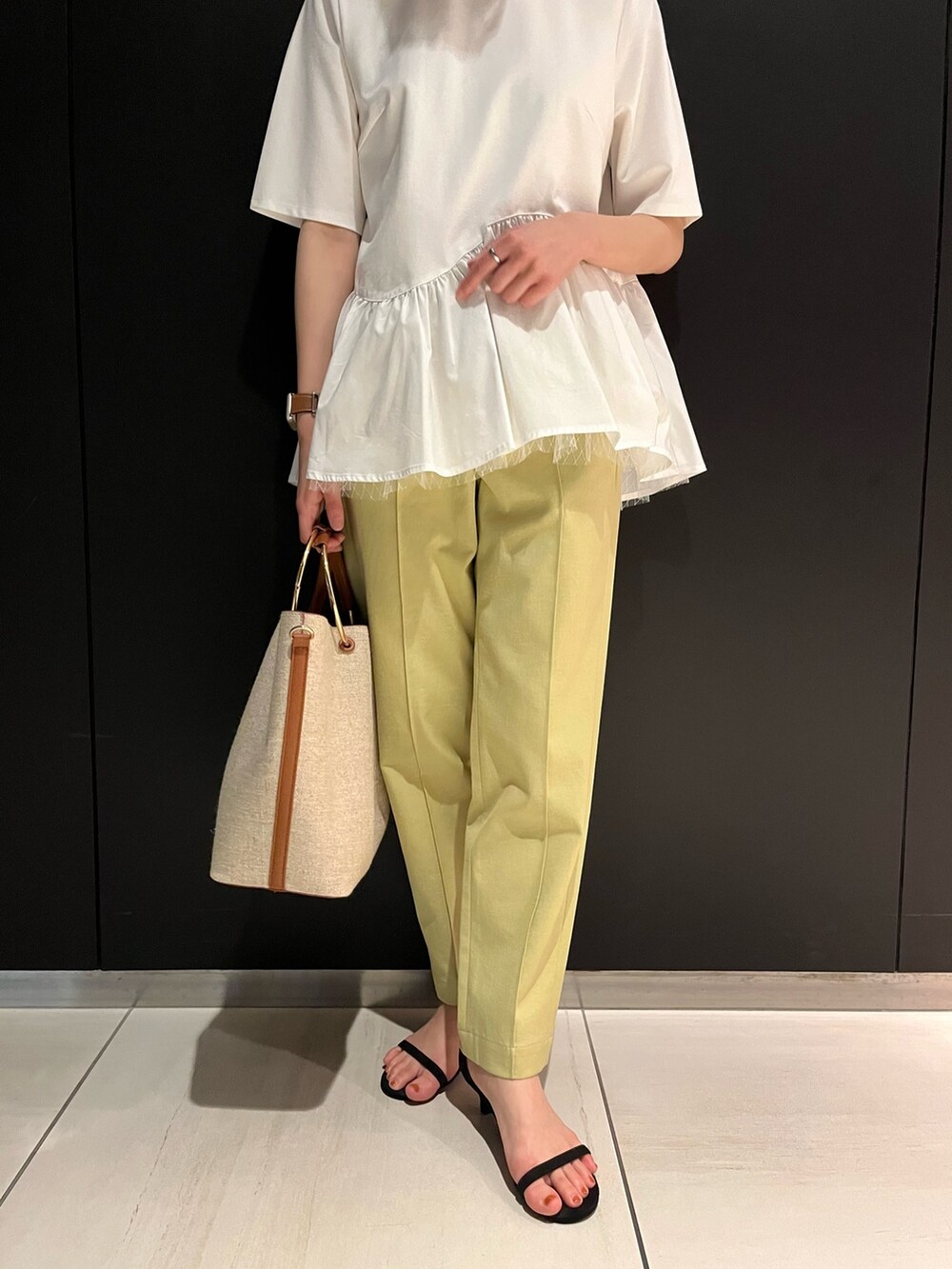 ホワイト系のTシャツ/カットソー、ブラウン系のハンドバッグ、イエロー系のその他パンツを着用したレディースの夏コーディネートの5枚目の写真