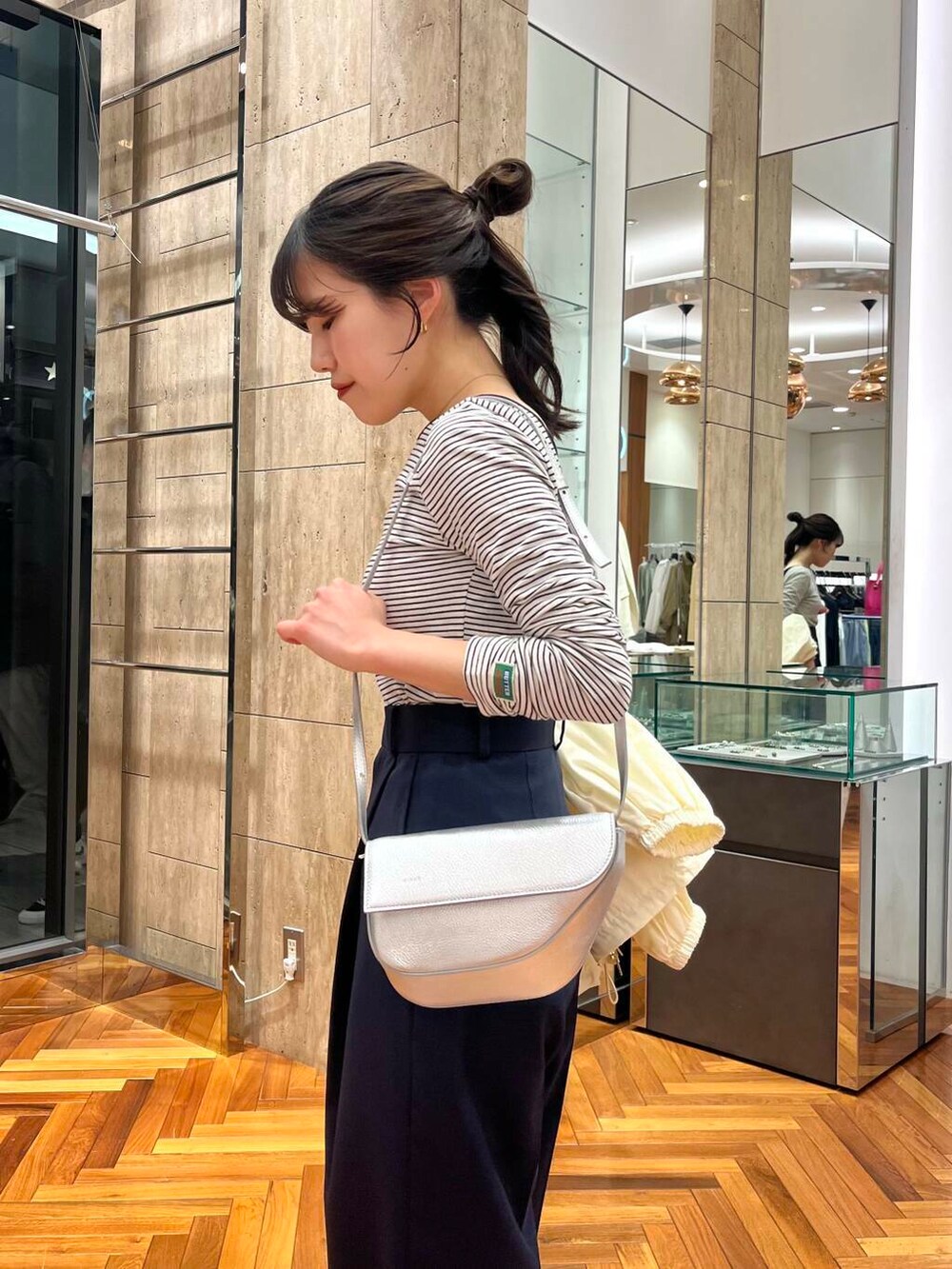 ホワイト系のブルゾン、ブルー系のその他パンツ、ブラック系のTシャツ/カットソーを着用したレディースの春コーディネートの7枚目の写真