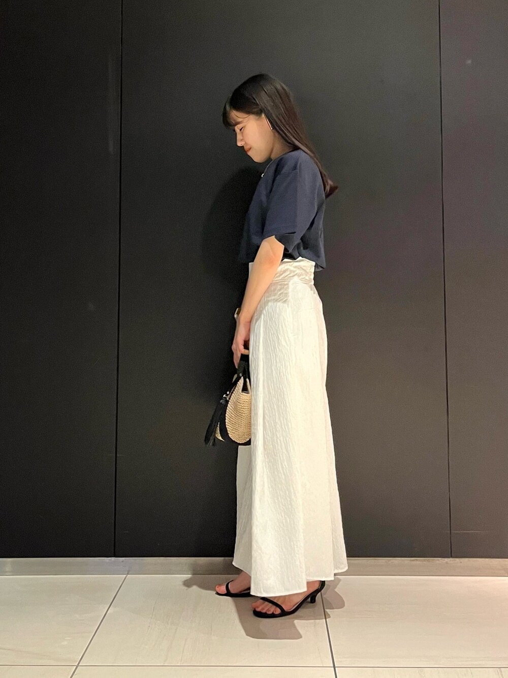 ブルー系のTシャツ/カットソー、ホワイト系のスカート、ベージュ系のハンドバッグを着用したレディースの春コーディネートの2枚目の写真