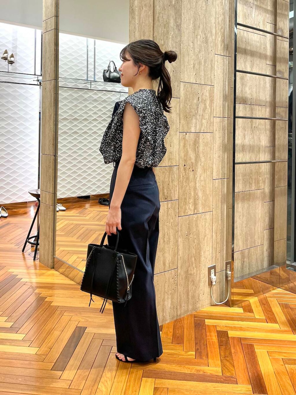 ブルー系のその他パンツ、ブラック系のショルダーバッグ、ブラック系のシャツ/ブラウスを着用したレディースの春コーディネートの2枚目の写真