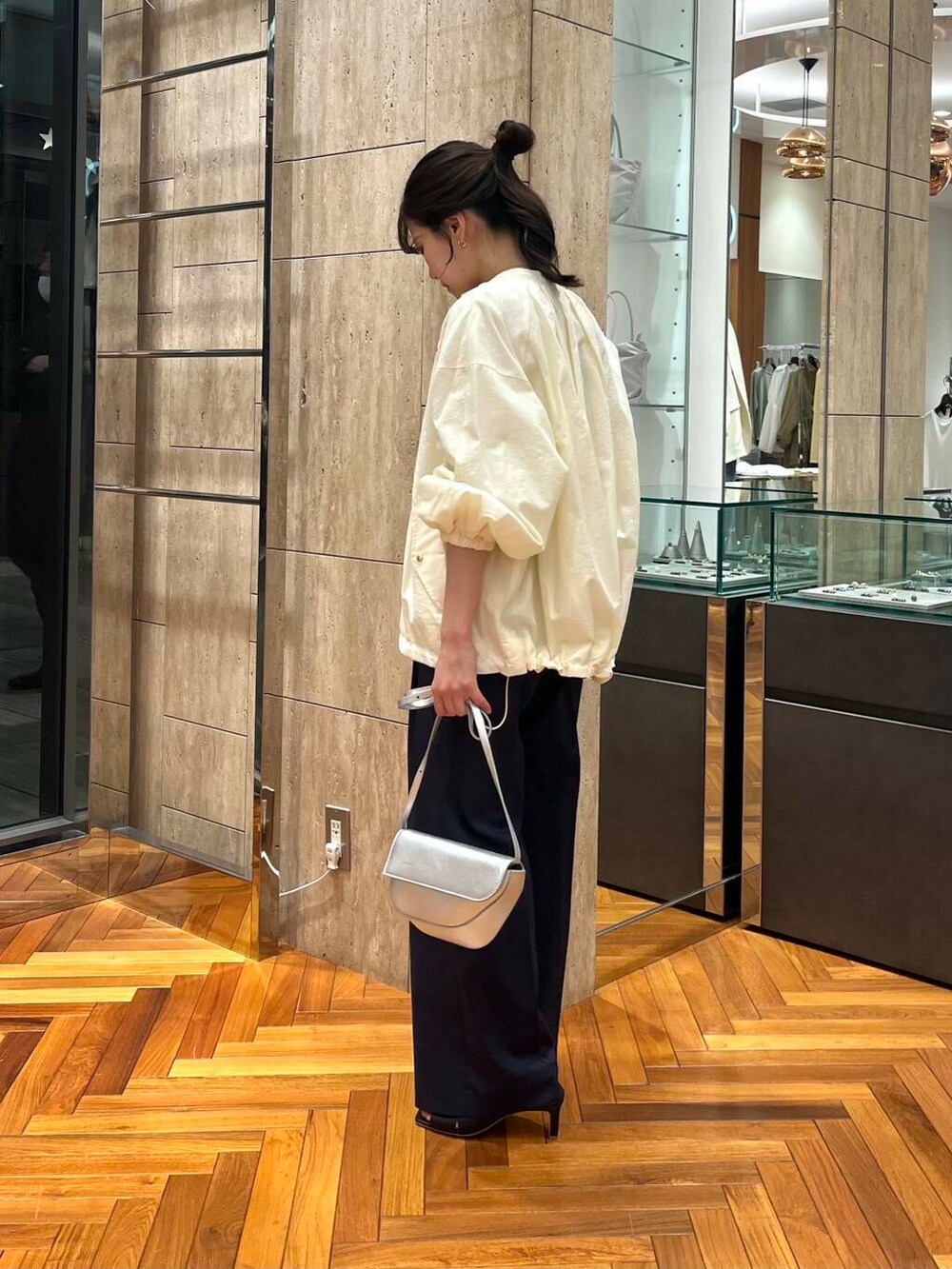 ホワイト系のブルゾン、ブルー系のその他パンツ、ブラック系のTシャツ/カットソーを着用したレディースの春コーディネートの2枚目の写真