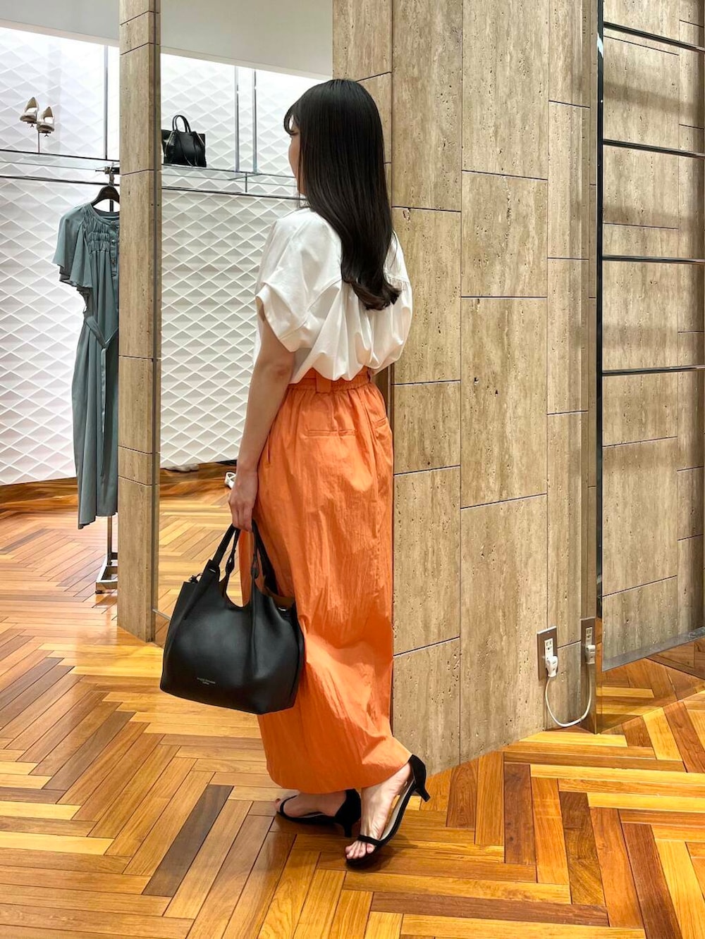 ホワイト系のシャツ/ブラウス、オレンジ系のスカートを着用したレディースの夏コーディネートの2枚目の写真