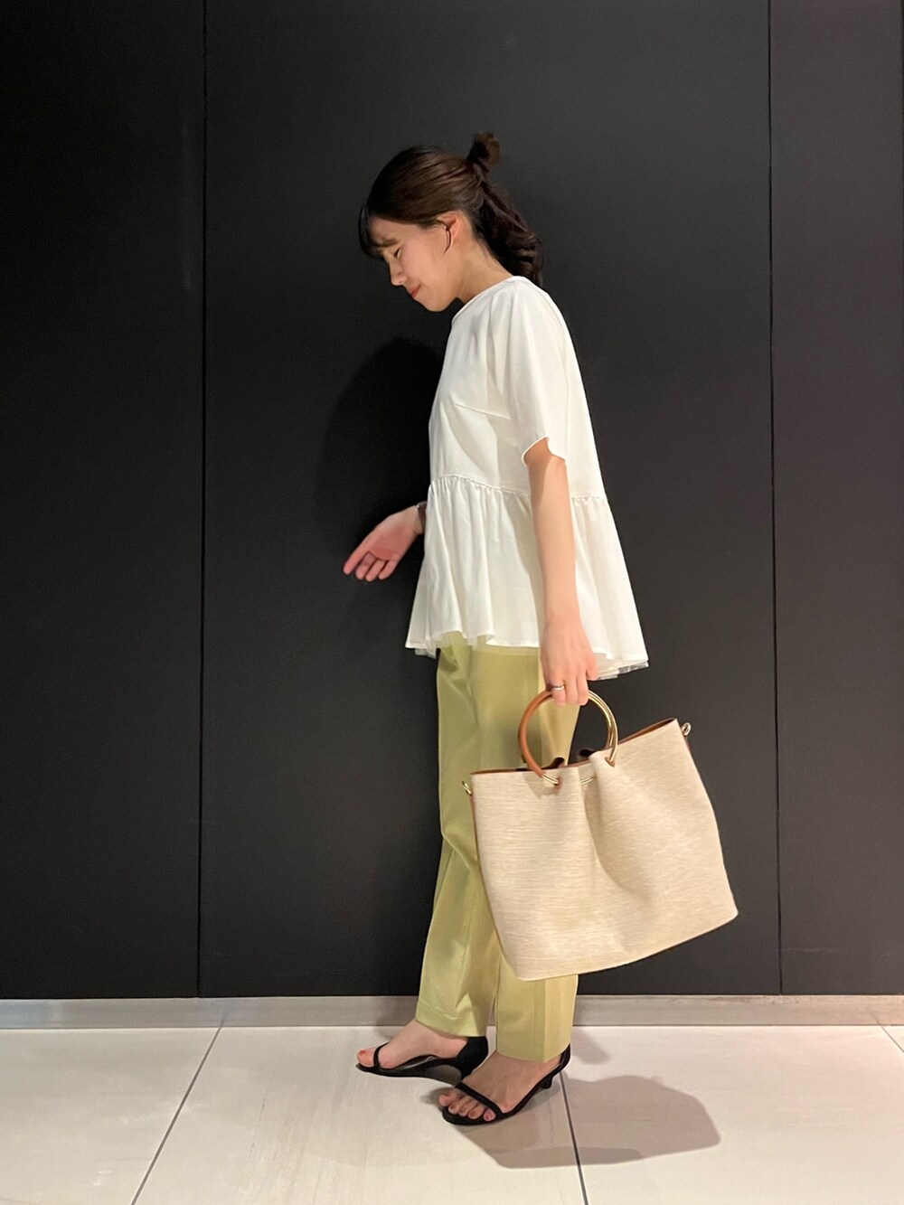 ホワイト系のTシャツ/カットソー、ブラウン系のハンドバッグ、イエロー系のその他パンツを着用したレディースの夏コーディネートの2枚目の写真