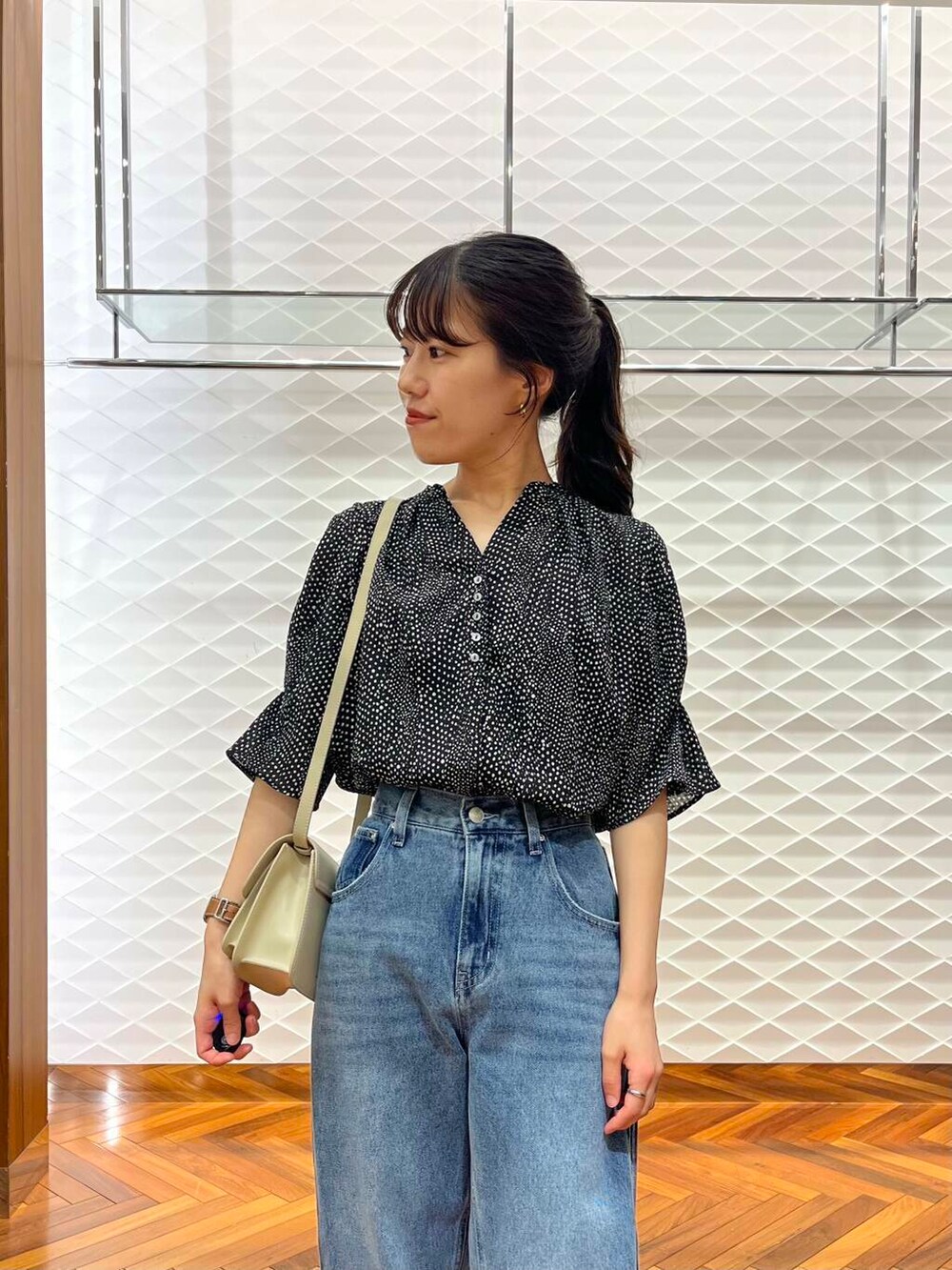 ブラック系のシャツ/ブラウス、ブルー系のデニムパンツ、ベージュ系のショルダーバッグを着用したレディースの夏コーディネートの3枚目の写真