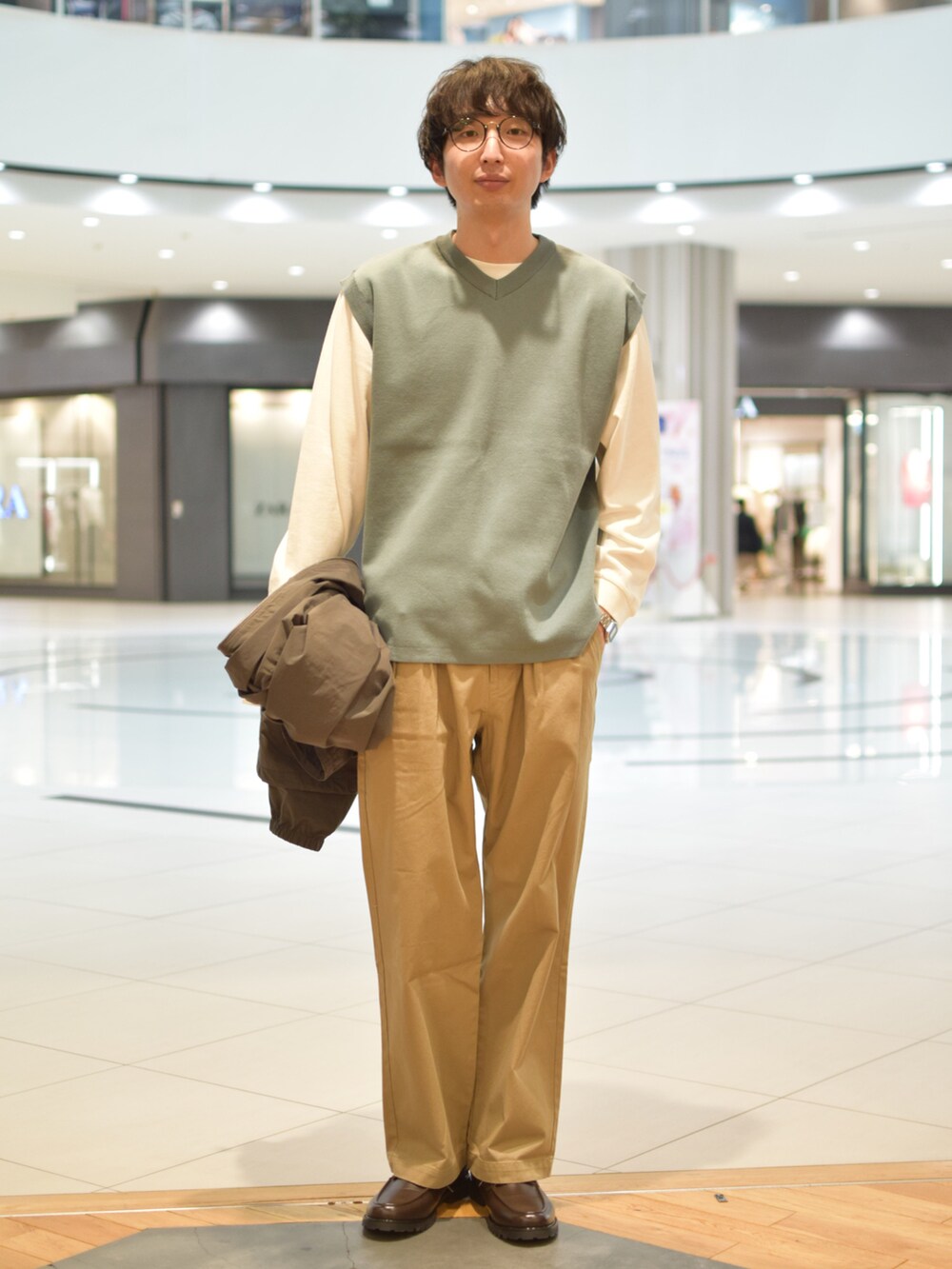 グレー系のマウンテンパーカー、ブルー系のベスト、ホワイト系のTシャツ/カットソーを着用したメンズの春コーディネートの2枚目の写真