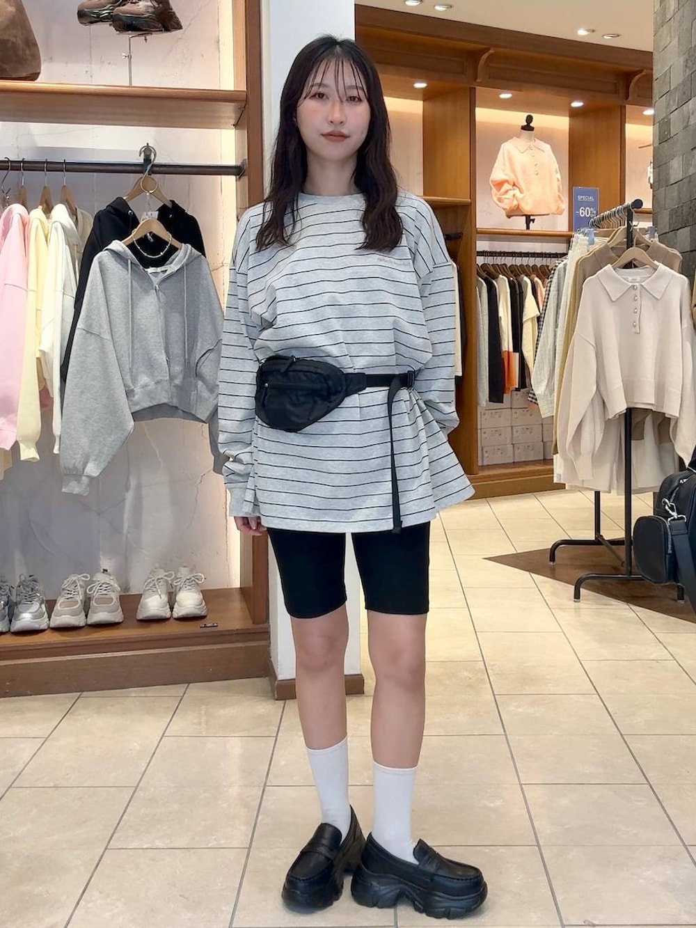 ブラック系のローファー、ブラック系のボディバッグ/ウエストポーチ、グレー系のTシャツ/カットソーを着用したレディースの冬コーディネートの5枚目の写真