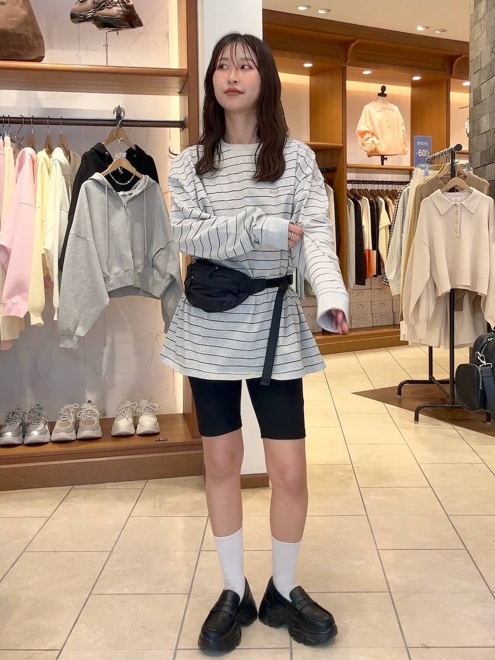 ブラック系のローファー、ブラック系のボディバッグ/ウエストポーチ、グレー系のTシャツ/カットソーを着用したレディースの冬コーディネートの2枚目の写真