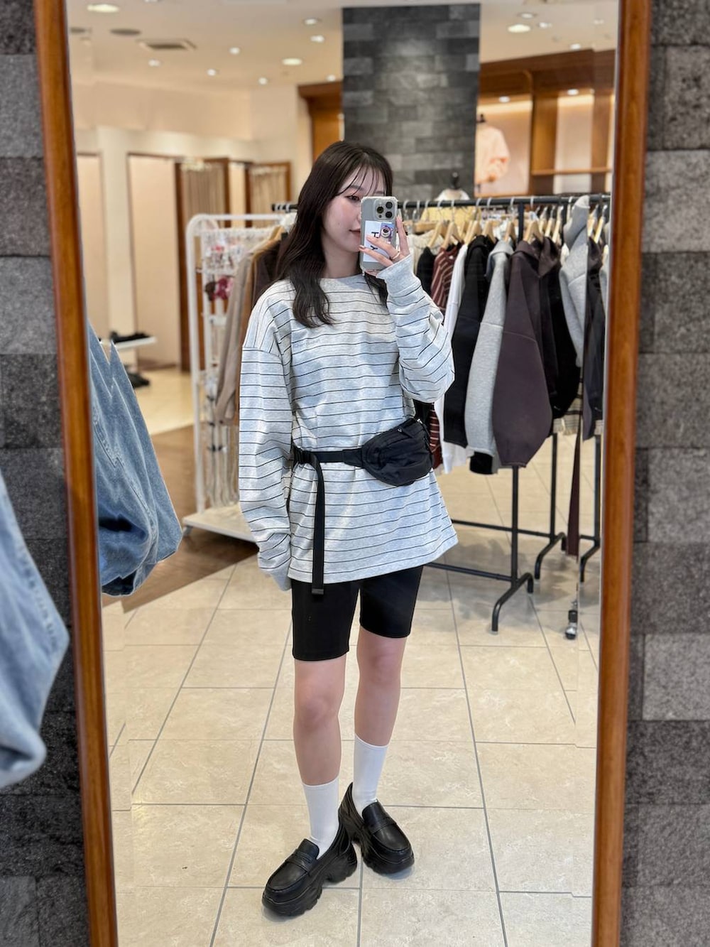 ブラック系のローファー、ブラック系のボディバッグ/ウエストポーチ、グレー系のTシャツ/カットソーを着用したレディースの冬コーディネートの8枚目の写真