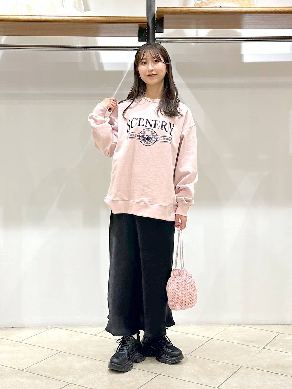 ブラック系のスカート、ブラック系のスニーカー、ピンク系のスウェットを着用したレディースの春コーディネートの5枚目の写真