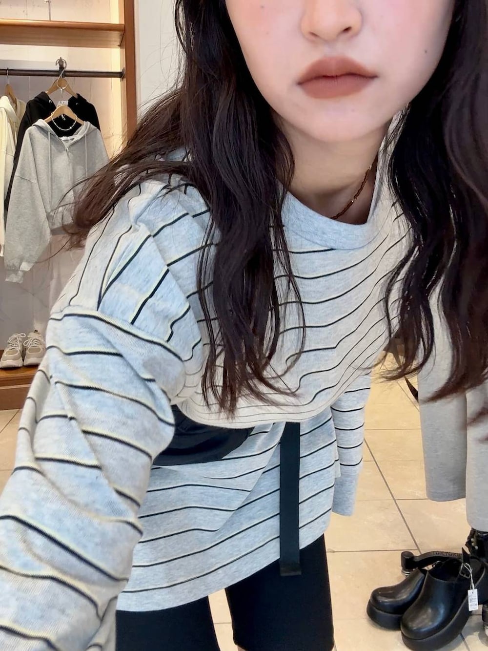 ブラック系のローファー、ブラック系のボディバッグ/ウエストポーチ、グレー系のTシャツ/カットソーを着用したレディースの冬コーディネートの6枚目の写真