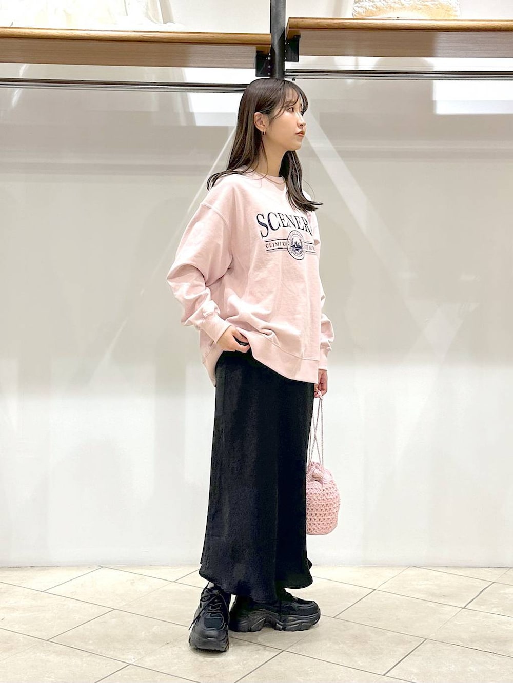 ブラック系のスカート、ブラック系のスニーカー、ピンク系のスウェットを着用したレディースの春コーディネートの4枚目の写真