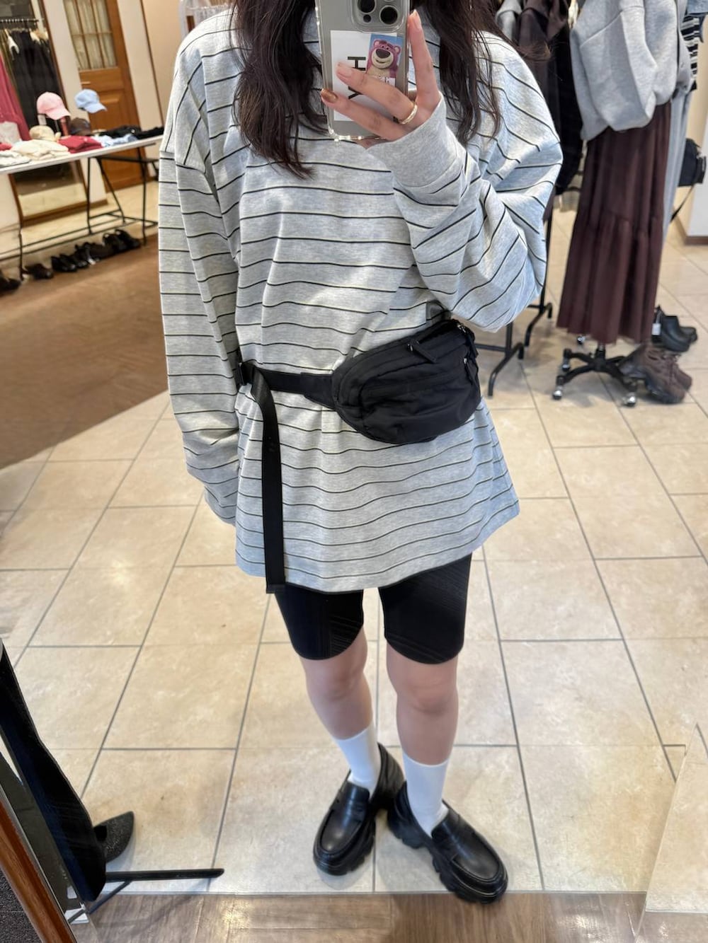 ブラック系のローファー、ブラック系のボディバッグ/ウエストポーチ、グレー系のTシャツ/カットソーを着用したレディースの冬コーディネートの7枚目の写真