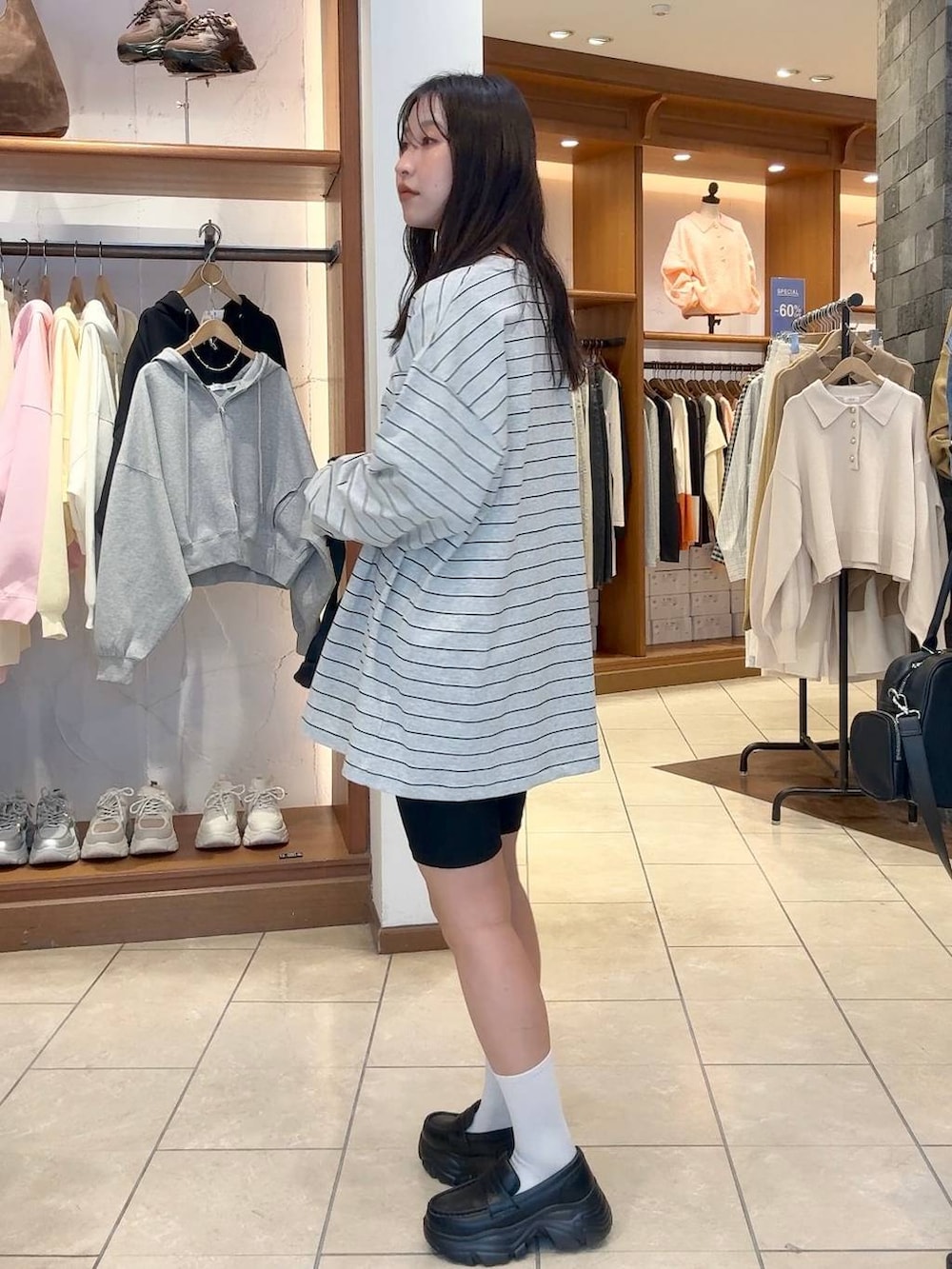 ブラック系のローファー、ブラック系のボディバッグ/ウエストポーチ、グレー系のTシャツ/カットソーを着用したレディースの冬コーディネートの3枚目の写真