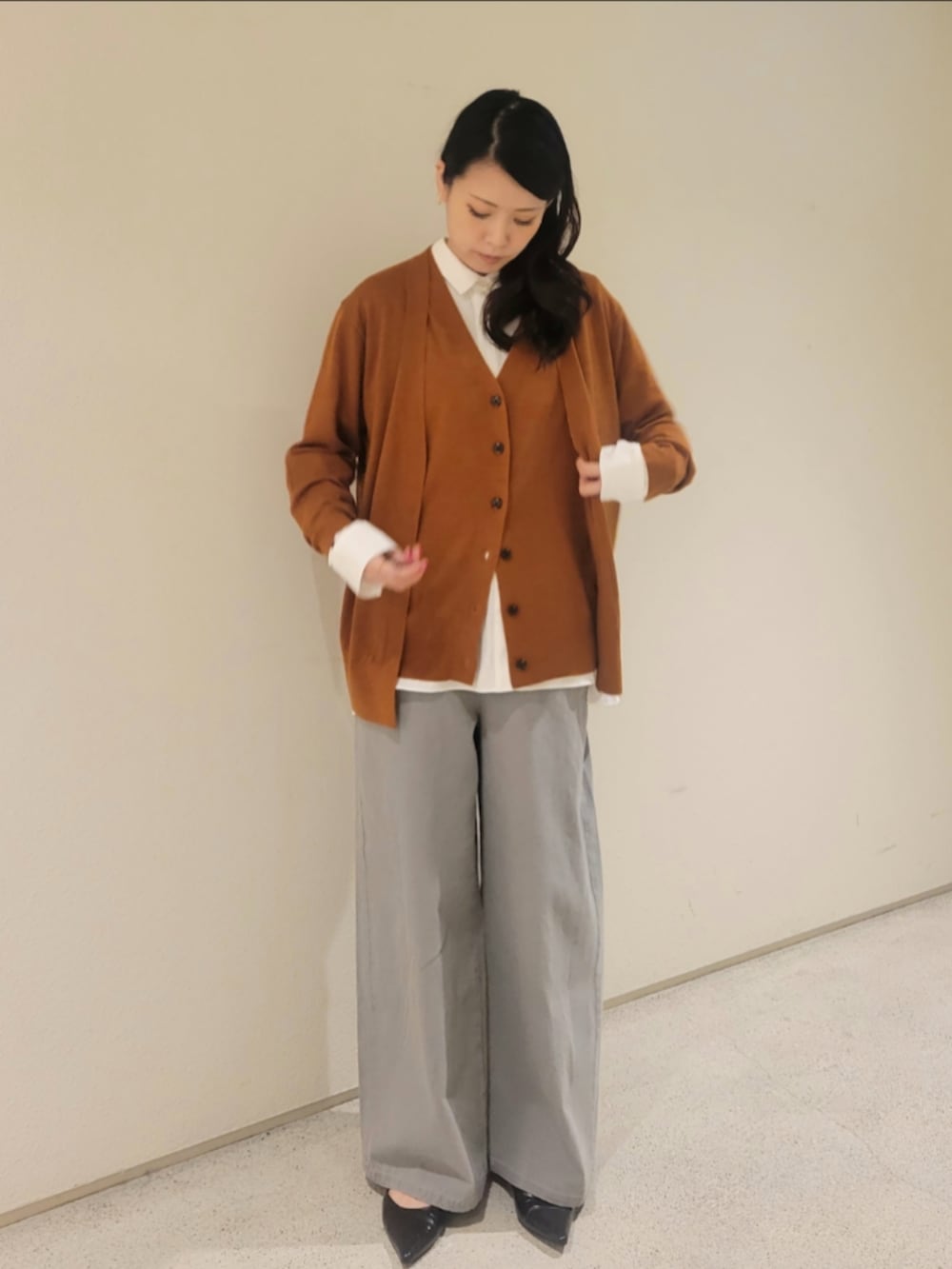 グレー系のデニムパンツ、レッド系のショルダーバッグ、ホワイト系のシャツ/ブラウスを着用したレディースの秋コーディネートの3枚目の写真