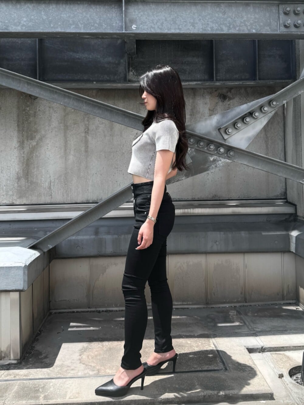 ホワイト系のニット/セーター、ブラック系のデニムパンツ、ブラック系のパンプスを着用したレディースの夏コーディネートの2枚目の写真