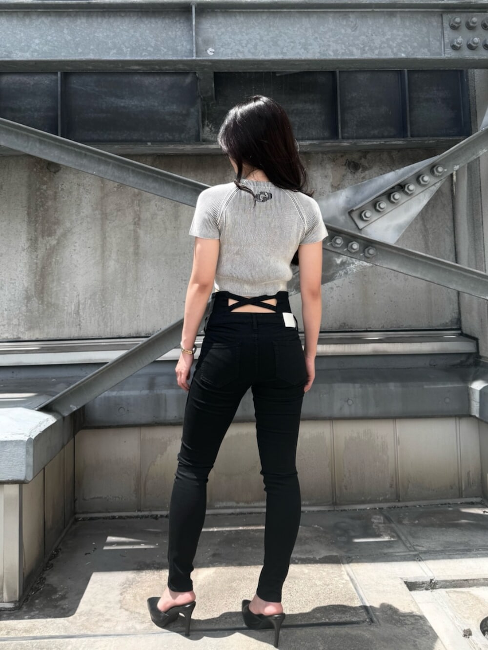 ホワイト系のニット/セーター、ブラック系のデニムパンツ、ブラック系のパンプスを着用したレディースの夏コーディネートの3枚目の写真