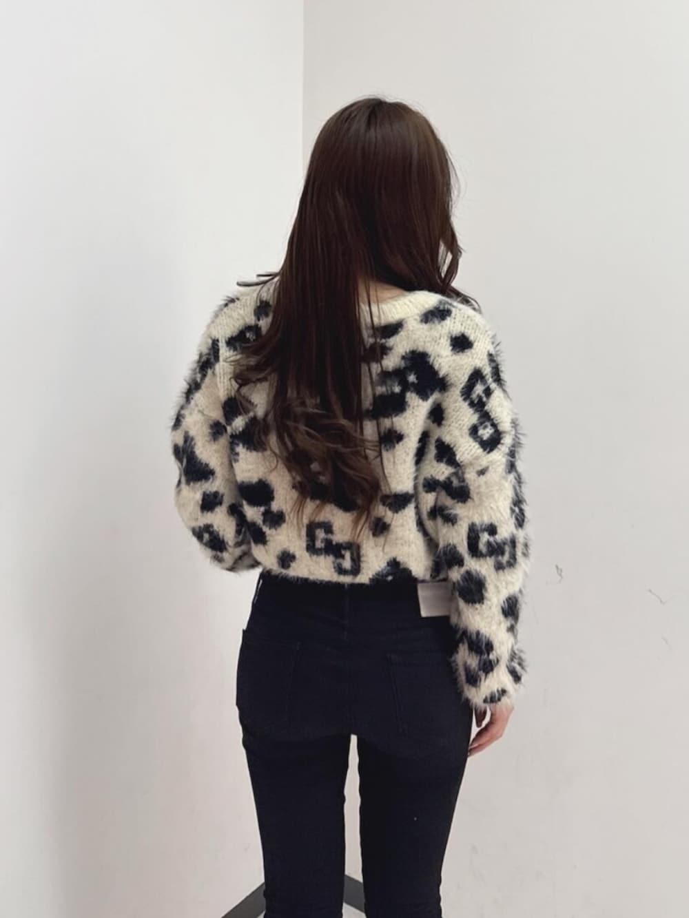 ブラック系のデニムパンツ、ホワイト系のニット/セーター、ブラック系のブーツを着用したレディースの冬コーディネートの4枚目の写真