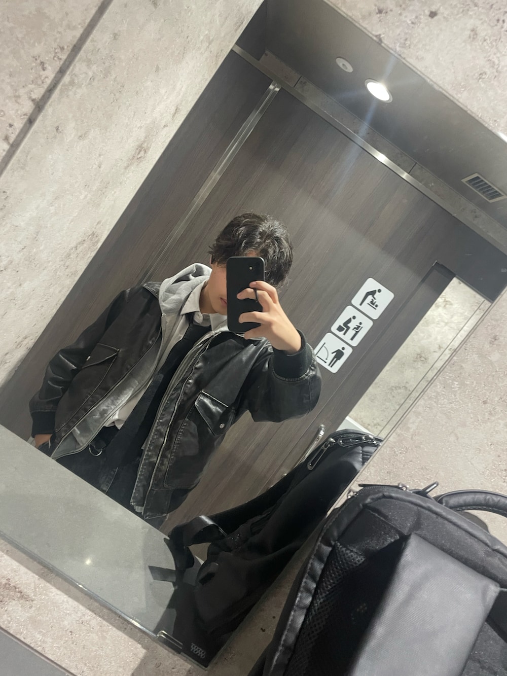 ブラック系のブルゾン、ブラック系のカーゴパンツ、グレー系のパーカーを着用したメンズの秋コーディネートの2枚目の写真