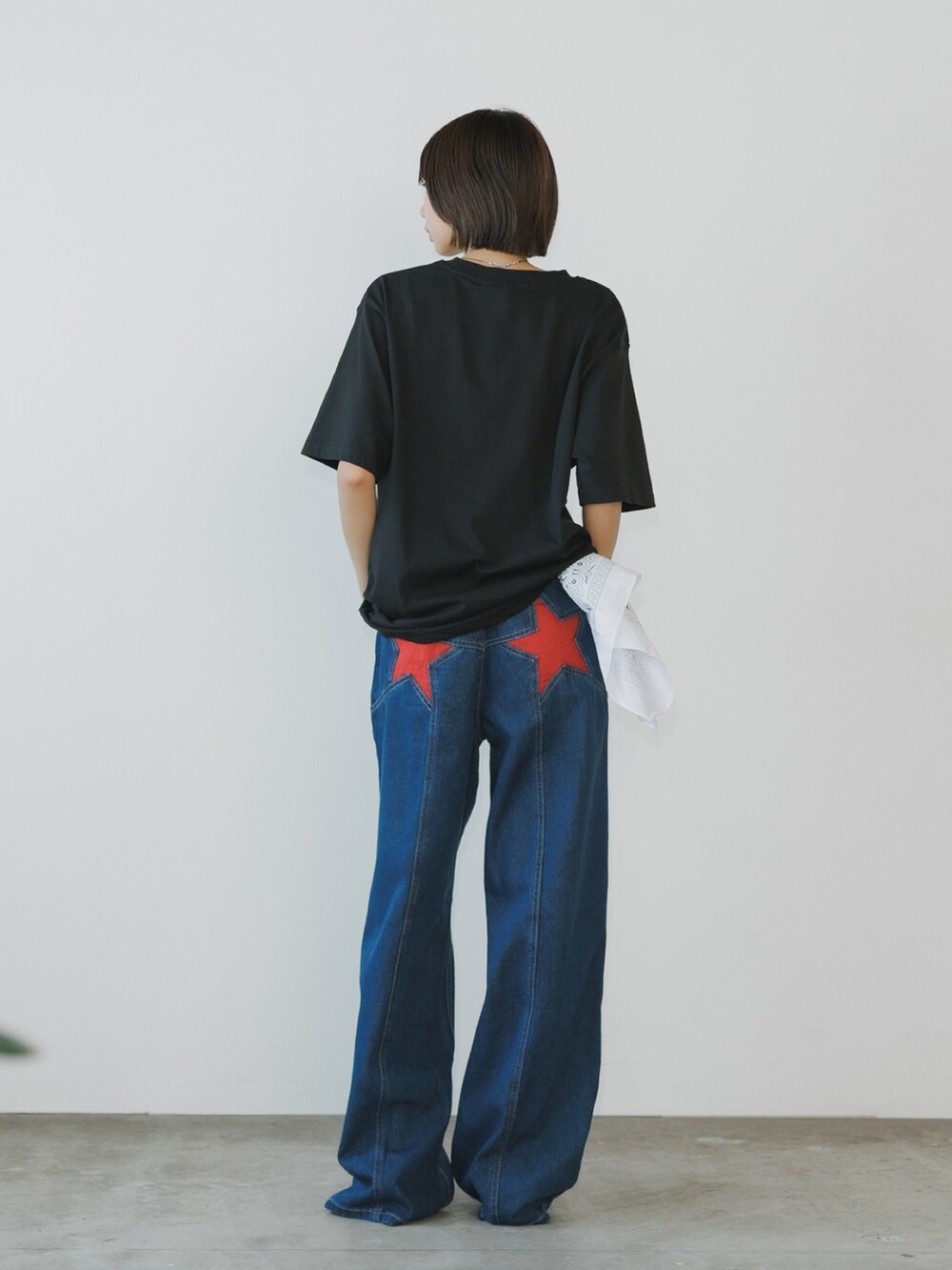 レッド系のデニムパンツ、ブラック系のTシャツ/カットソーを着用したレディースの夏コーディネートの2枚目の写真