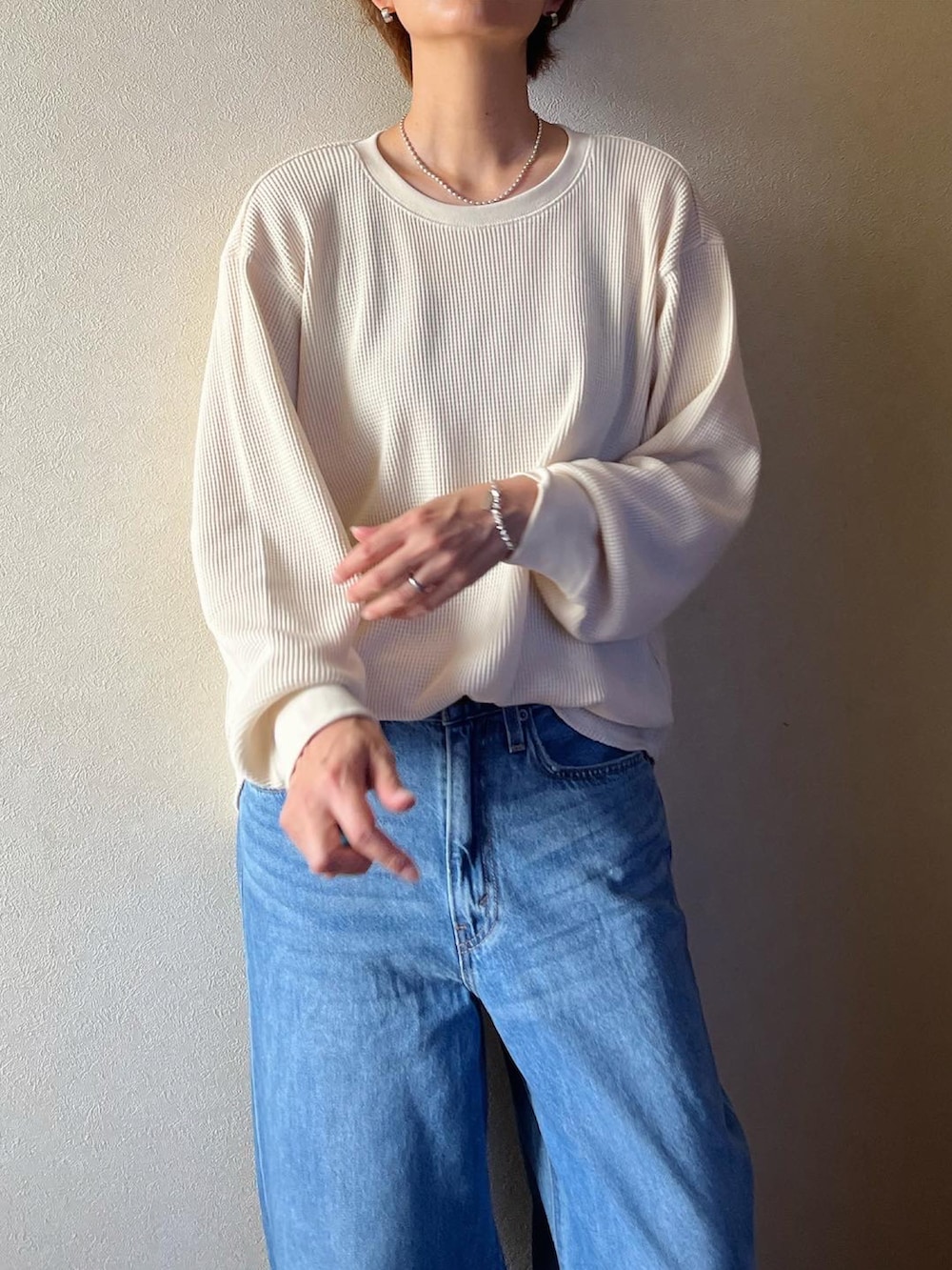 ホワイト系のTシャツ/カットソー、ブルー系のデニムパンツ、ホワイト系のサンダルを着用したレディースの夏コーディネートの3枚目の写真