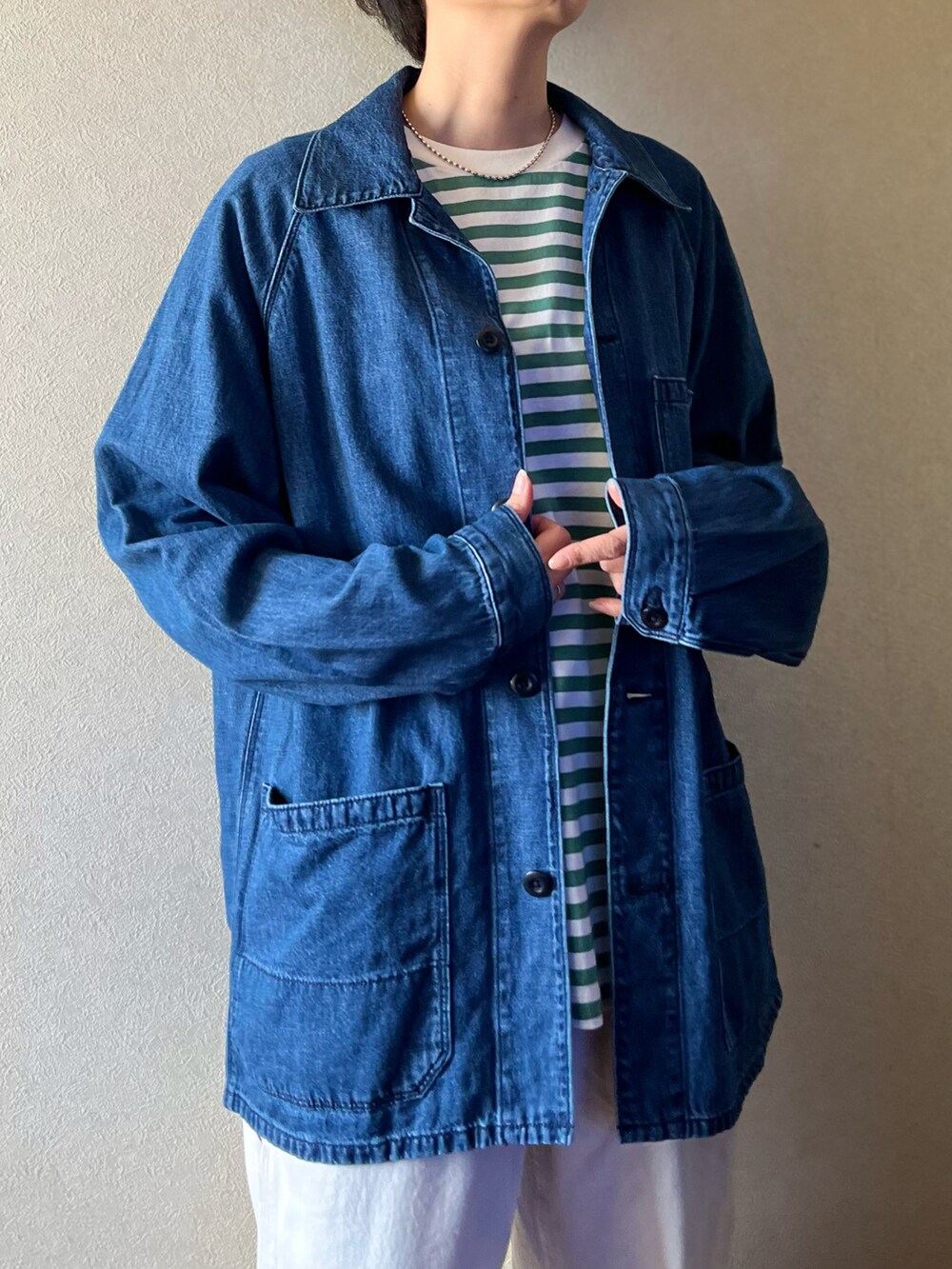 グリーン系のTシャツ/カットソー、ブルー系のデニムジャケット、ホワイト系のデニムパンツを着用したレディースの春コーディネートの2枚目の写真
