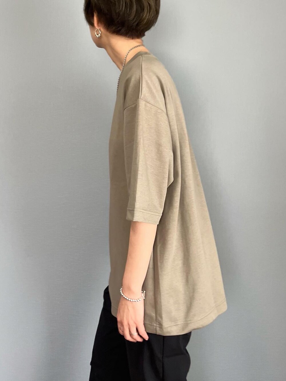 グリーン系のTシャツ/カットソー、ブラック系のパンツ、ブラック系のショルダーバッグを着用したレディースの春コーディネートの3枚目の写真