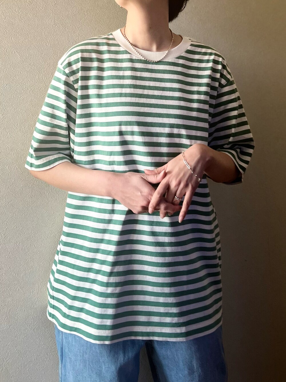 グリーン系のTシャツ/カットソー、ブルー系のデニムジャケット、ホワイト系のデニムパンツを着用したレディースの春コーディネートの4枚目の写真