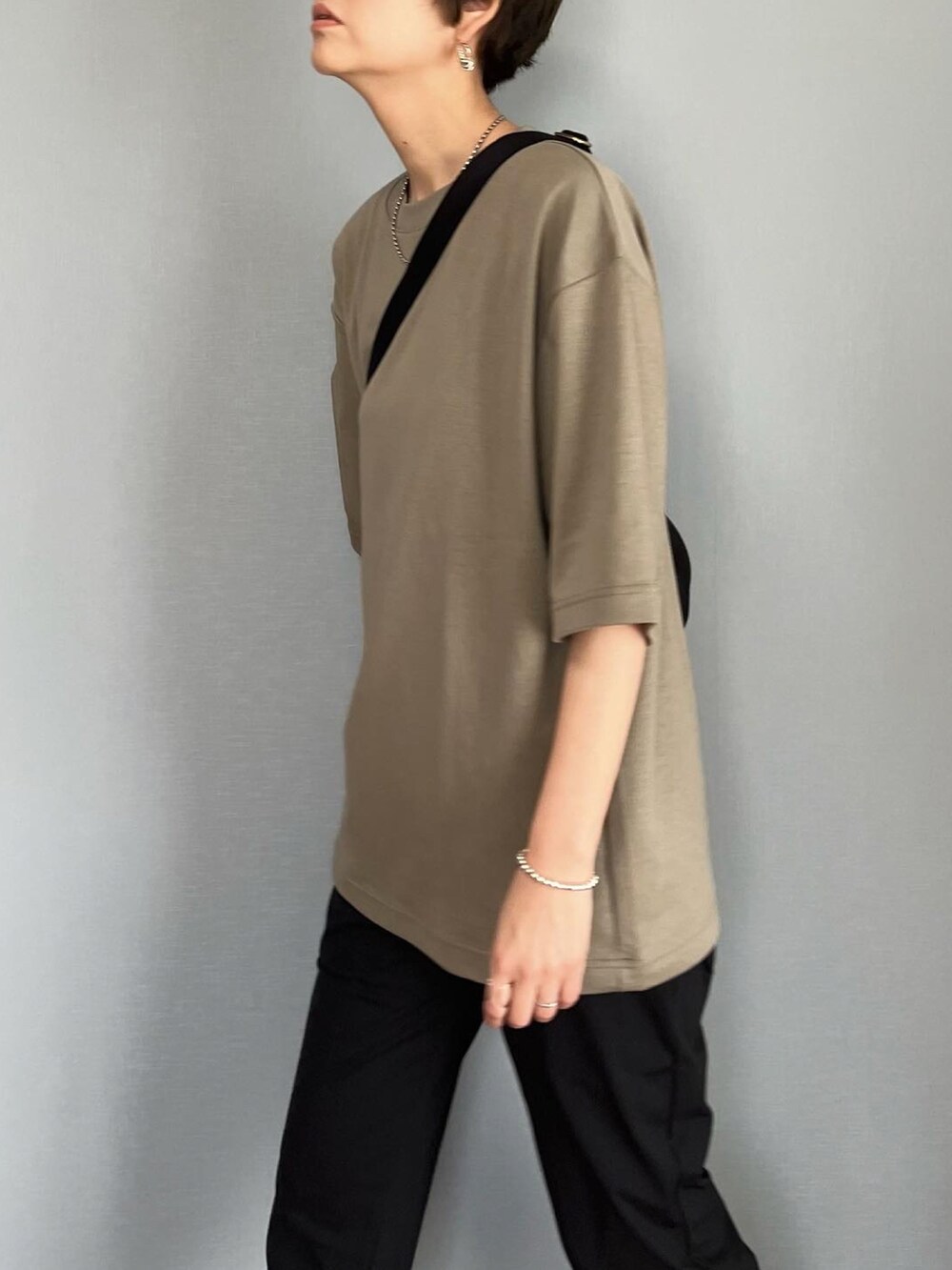 グリーン系のTシャツ/カットソー、ブラック系のパンツ、ブラック系のショルダーバッグを着用したレディースの春コーディネートの2枚目の写真