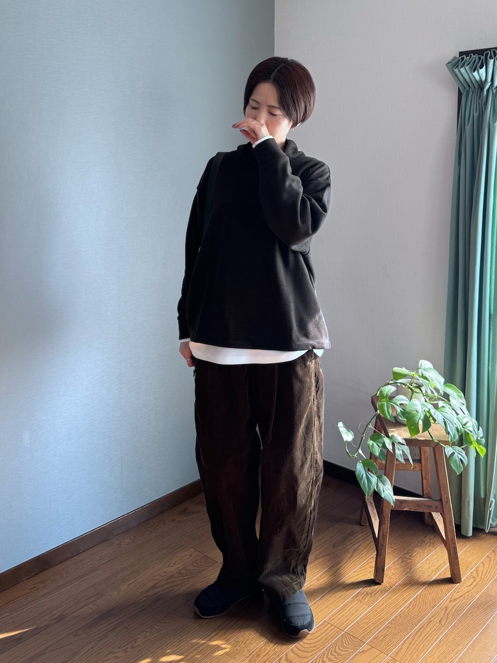 ブラック系のトップス、ホワイト系のTシャツ/カットソー、ブラウン系のパンツを着用したレディースの秋コーディネートの2枚目の写真