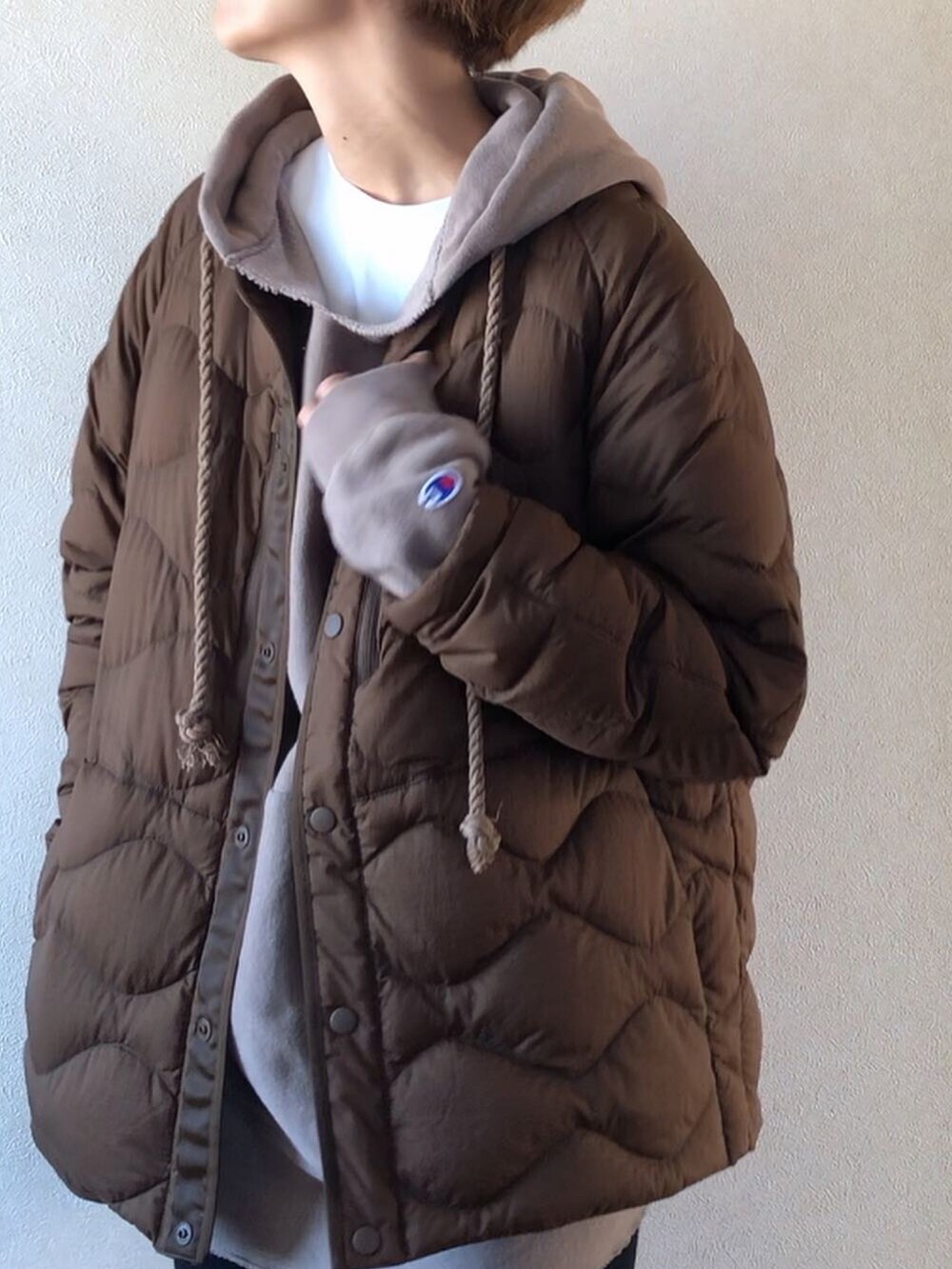 ブラウン系のダウンジャケット/コート、ホワイト系のスウェットパンツ、ブラウン系のスニーカーを着用したレディースの秋コーディネートの3枚目の写真