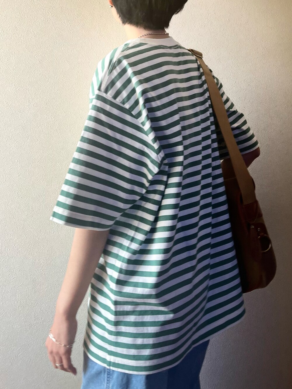 グリーン系のTシャツ/カットソー、ブルー系のデニムジャケット、ホワイト系のデニムパンツを着用したレディースの春コーディネートの5枚目の写真