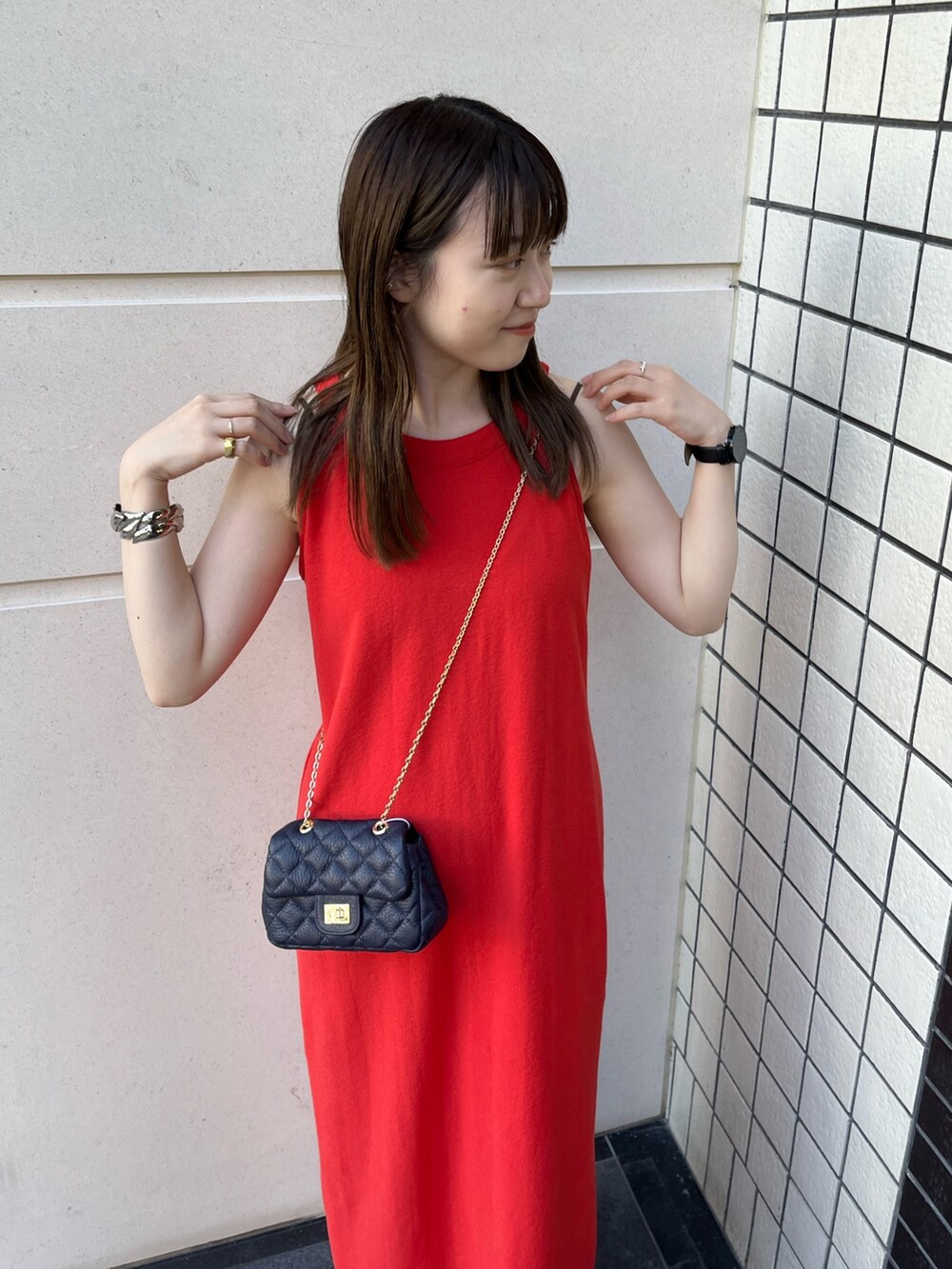 ブルー系のショルダーバッグ、レッド系のワンピースを着用したレディースの夏コーディネートの3枚目の写真