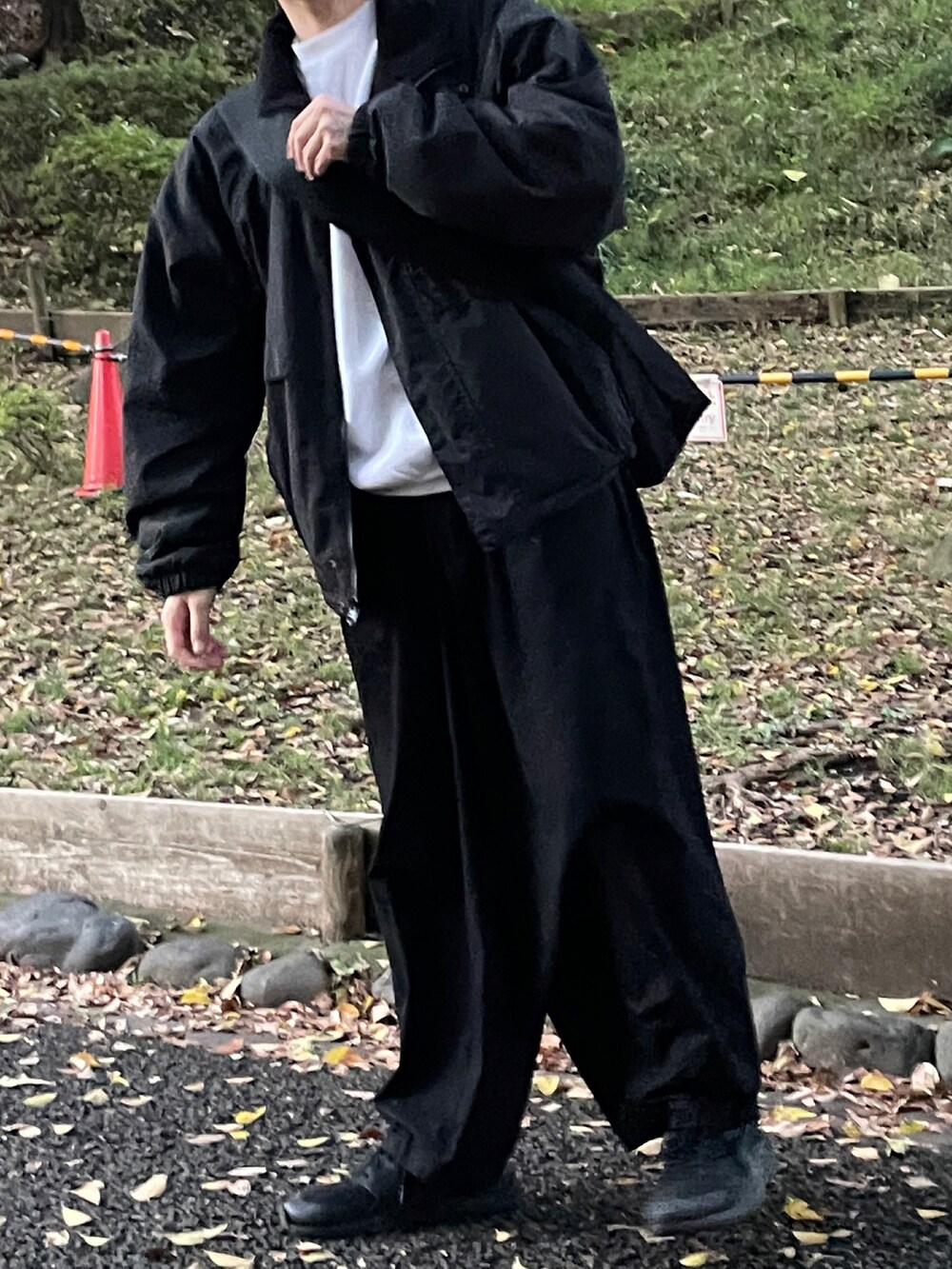 ブラック系のブルゾン、ブラック系のチノパンツ、ブラック系のスニーカーを着用したメンズの秋コーディネートの2枚目の写真