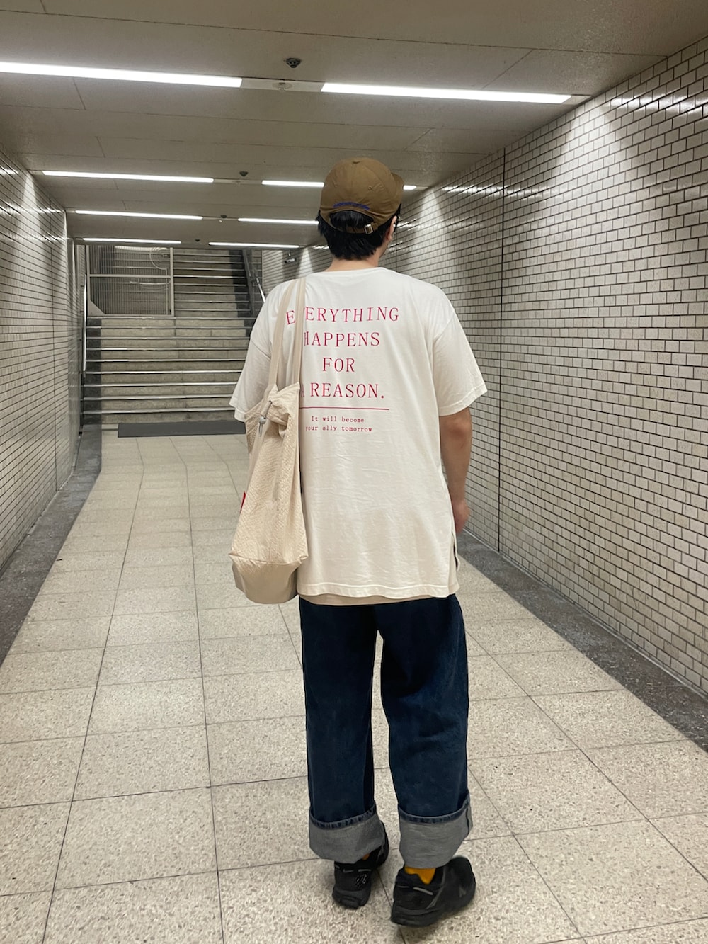 ブラック系のスニーカー、ホワイト系のTシャツ/カットソー、ブルー系のデニムパンツを着用したメンズの秋コーディネートの3枚目の写真