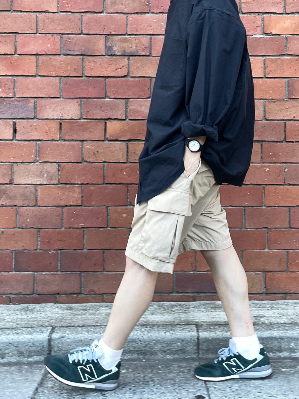 ブラック系のシャツ/ブラウス、ベージュ系のカーゴパンツ、グリーン系のスニーカーを着用したメンズの夏コーディネートの2枚目の写真