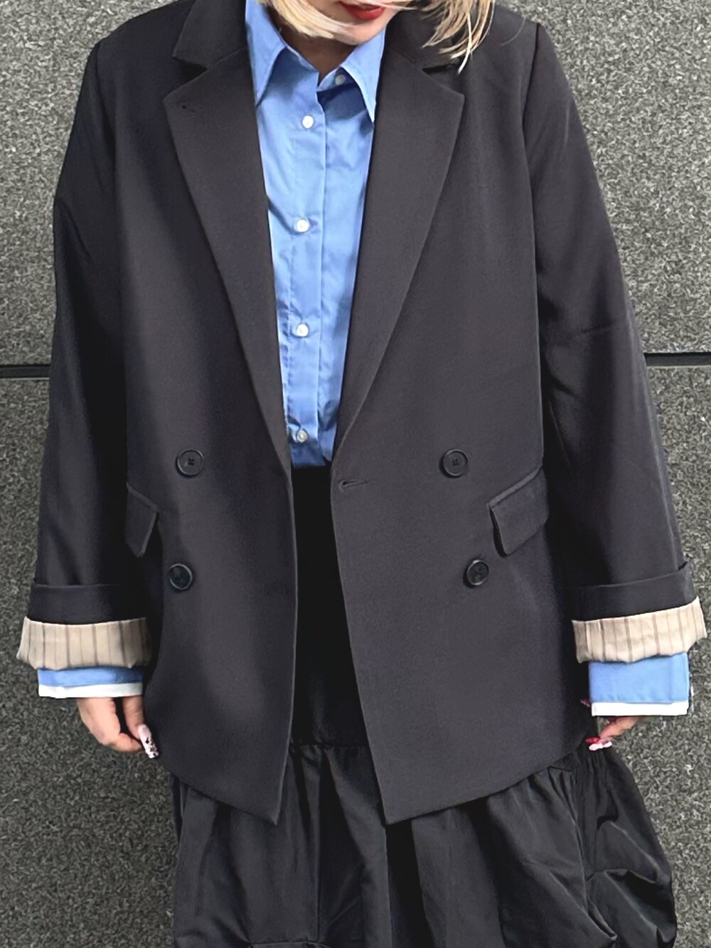 グレー系のテーラードジャケット、ブルー系のシャツ/ブラウス、グレー系のスカートを着用したレディースの冬コーディネートの3枚目の写真