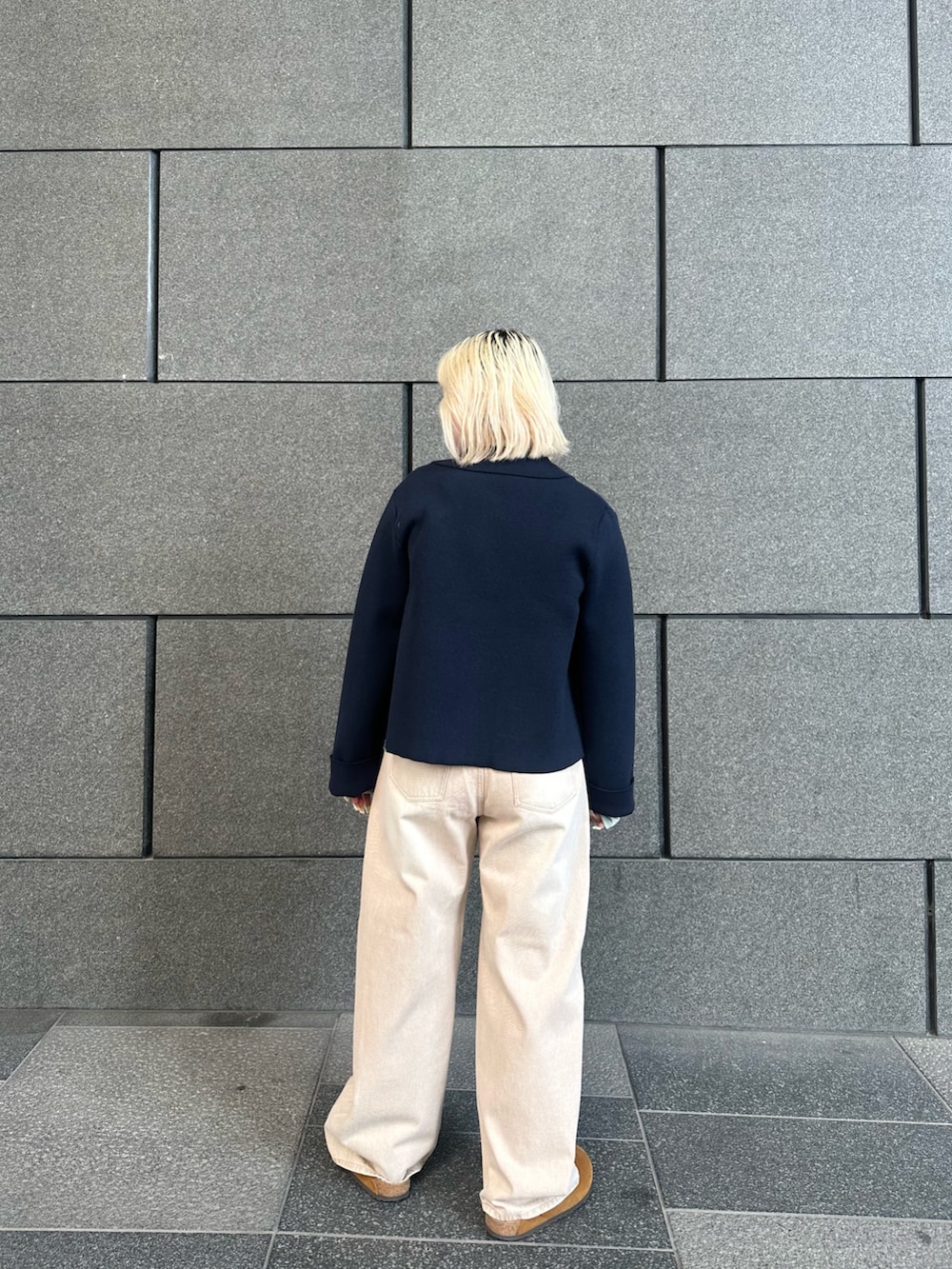 ブルー系のニット/セーター、グリーン系のシャツ/ブラウス、ベージュ系のデニムパンツを着用したレディースの冬コーディネートの2枚目の写真