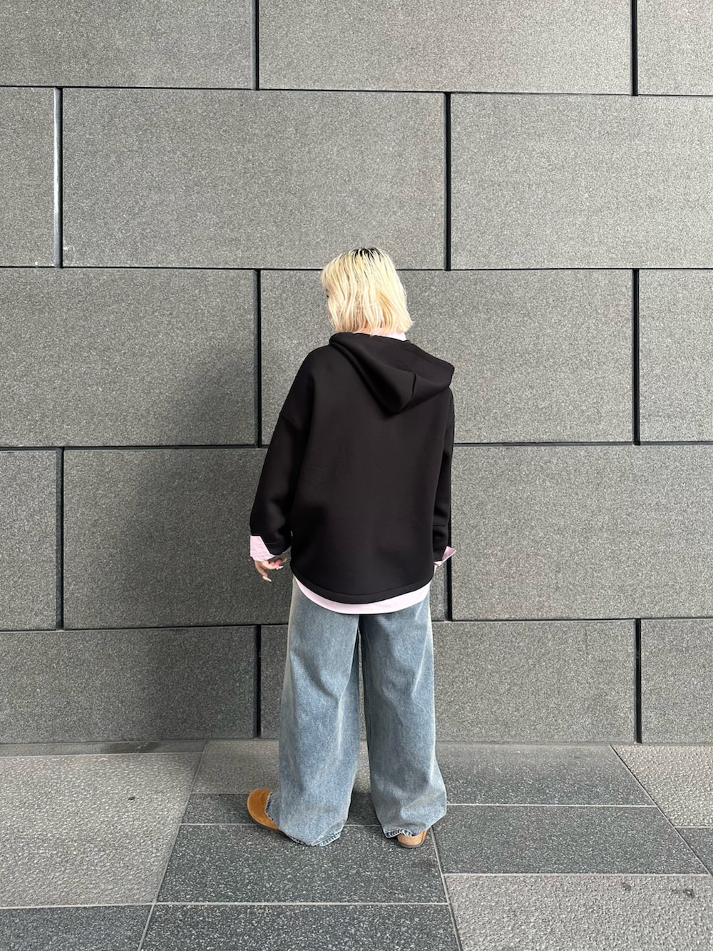 ブラック系のパーカー、ピンク系のシャツ/ブラウス、ブルー系のデニムパンツを着用したレディースの冬コーディネートの2枚目の写真