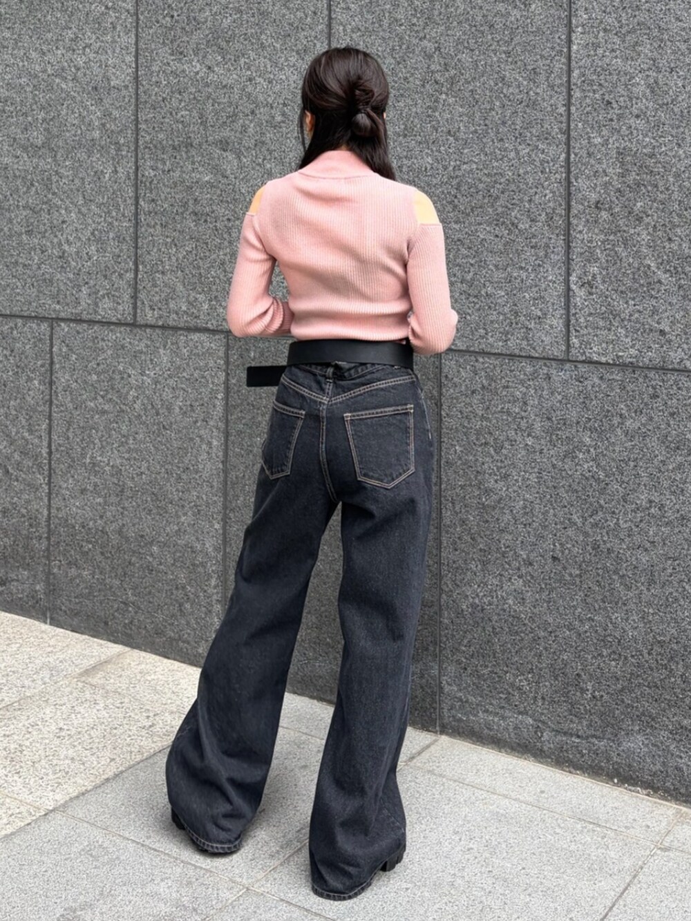 ピンク系のニット/セーター、ブルー系のデニムパンツ、ブラック系のブーツを着用したレディースの春コーディネートの3枚目の写真