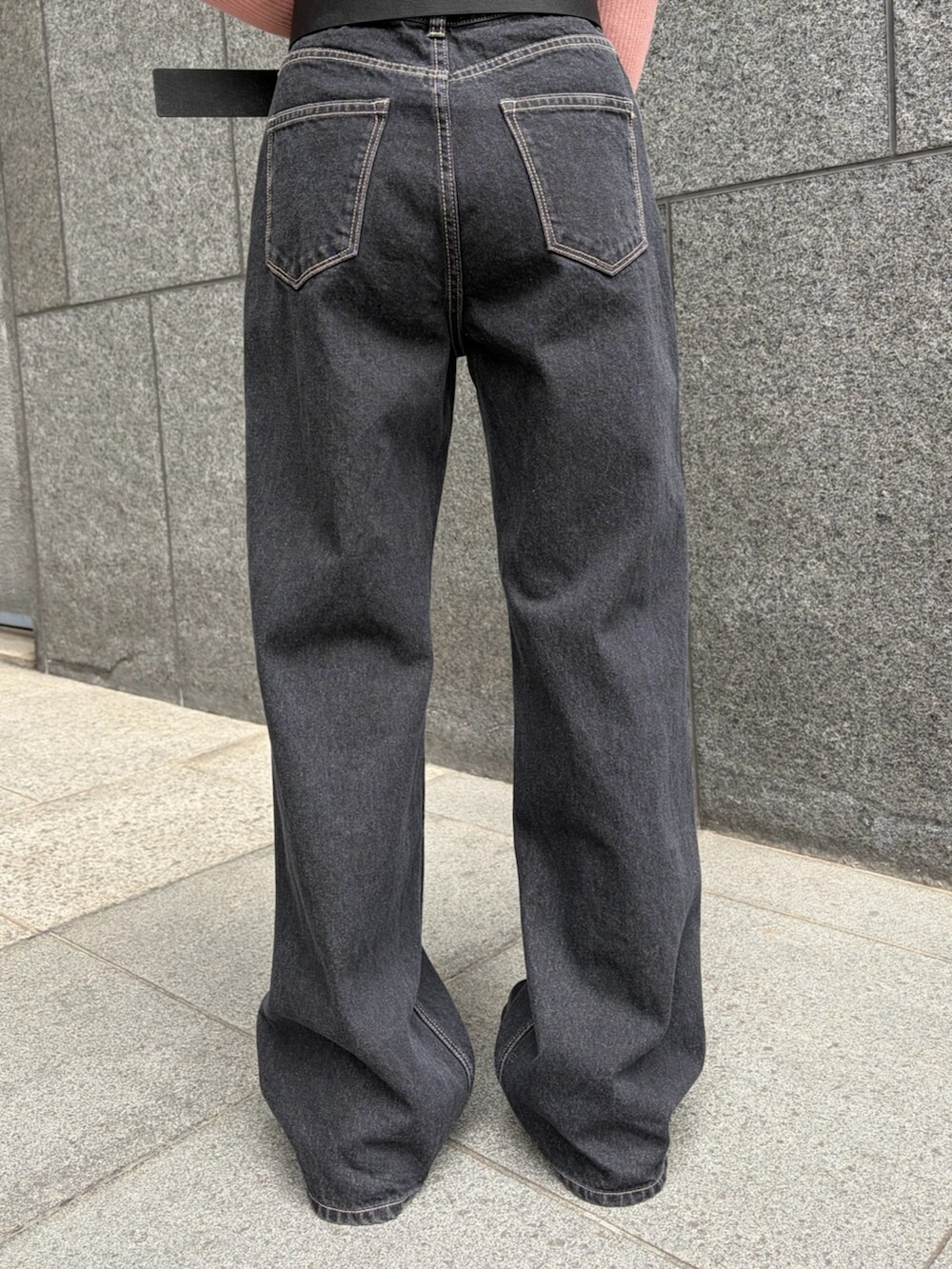 ピンク系のニット/セーター、ブルー系のデニムパンツ、ブラック系のブーツを着用したレディースの春コーディネートの6枚目の写真