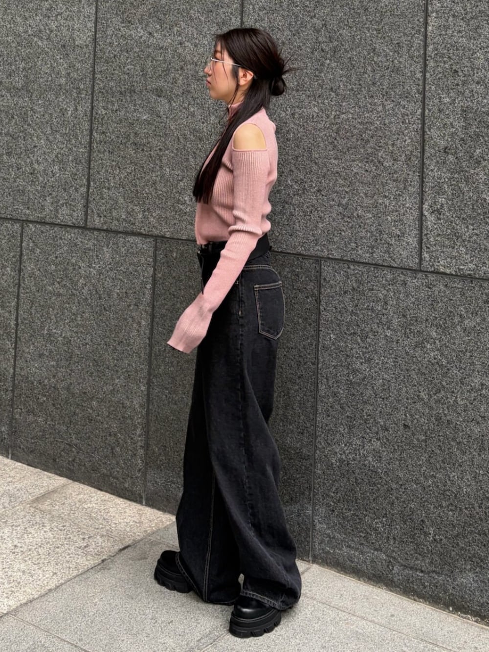 ピンク系のニット/セーター、ブルー系のデニムパンツ、ブラック系のブーツを着用したレディースの春コーディネートの2枚目の写真