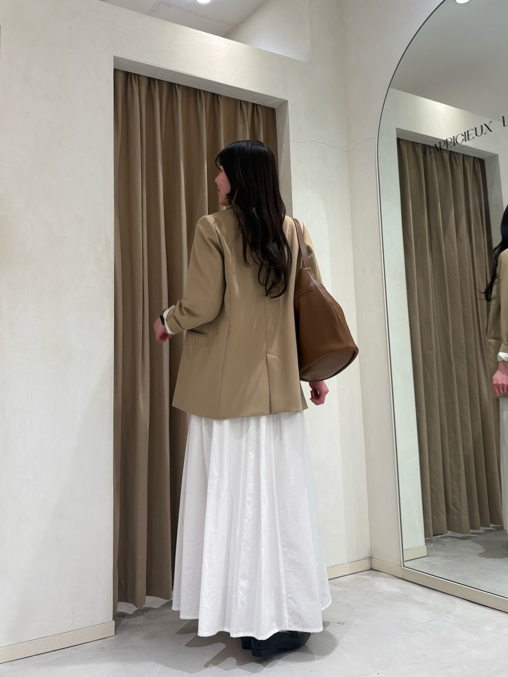 ピンク系のTシャツ/カットソー、ベージュ系のテーラードジャケット、ホワイト系のスカートを着用したレディースの春コーディネートの2枚目の写真