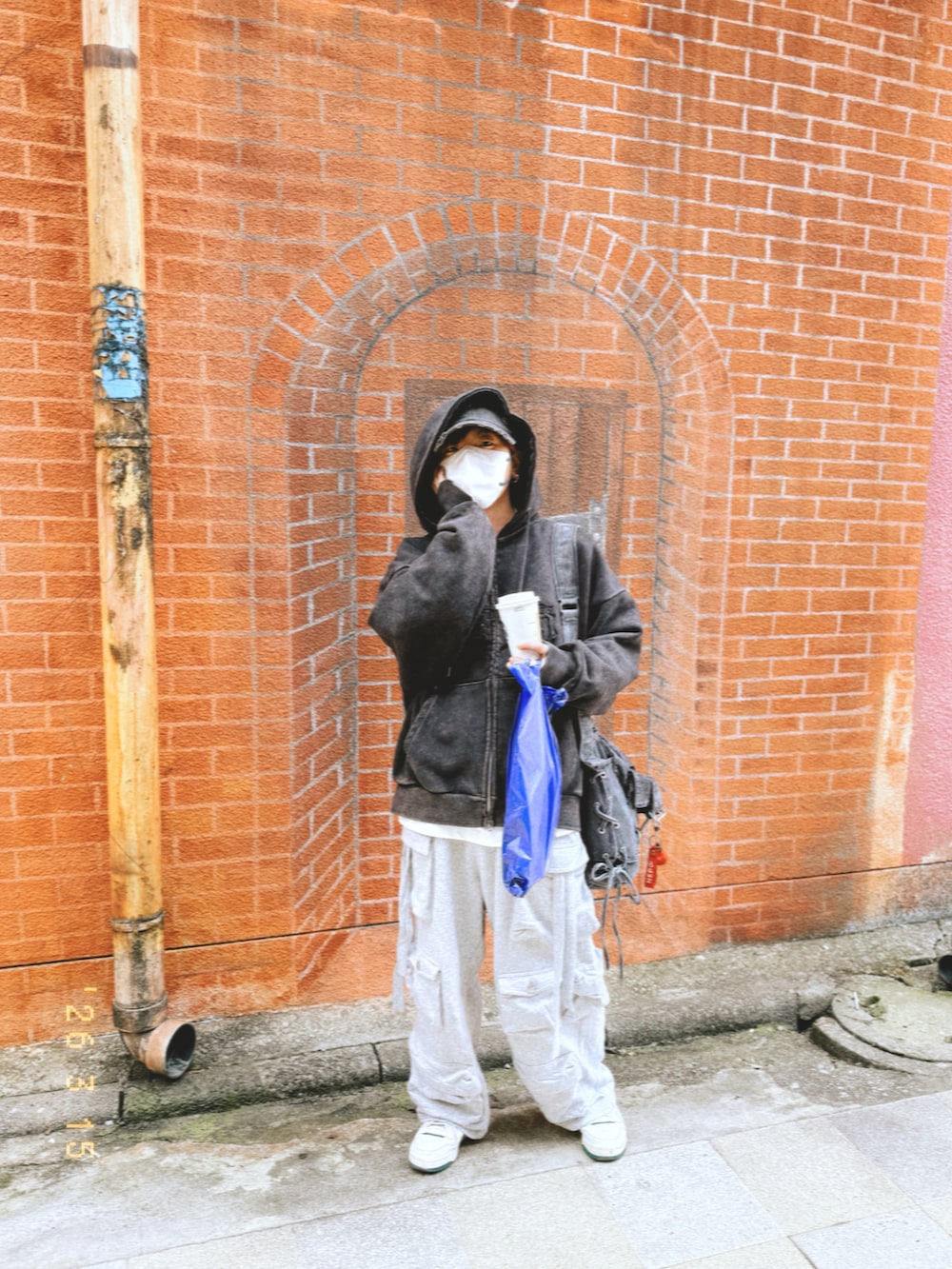 ブラック系のパーカー、グレー系のカーゴパンツ、ブラック系のショルダーバッグを着用したメンズの春コーディネートの3枚目の写真