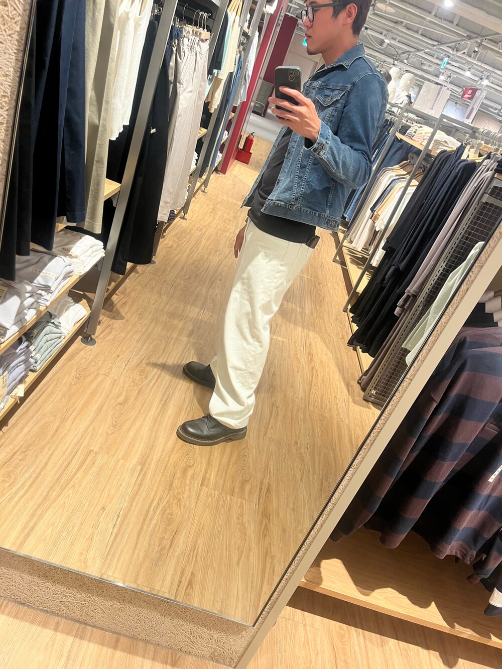 ブルー系のデニムジャケット、ブラック系のTシャツ/カットソー、ホワイト系のデニムパンツを着用したメンズの春コーディネートの2枚目の写真